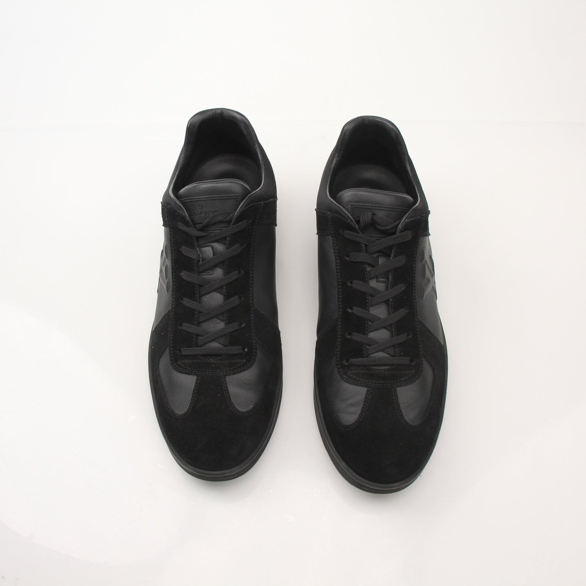 Black Louis Vuitton low top sneakers by Gold & Beyond, featuring sleek design and stylish laces on a clean background.