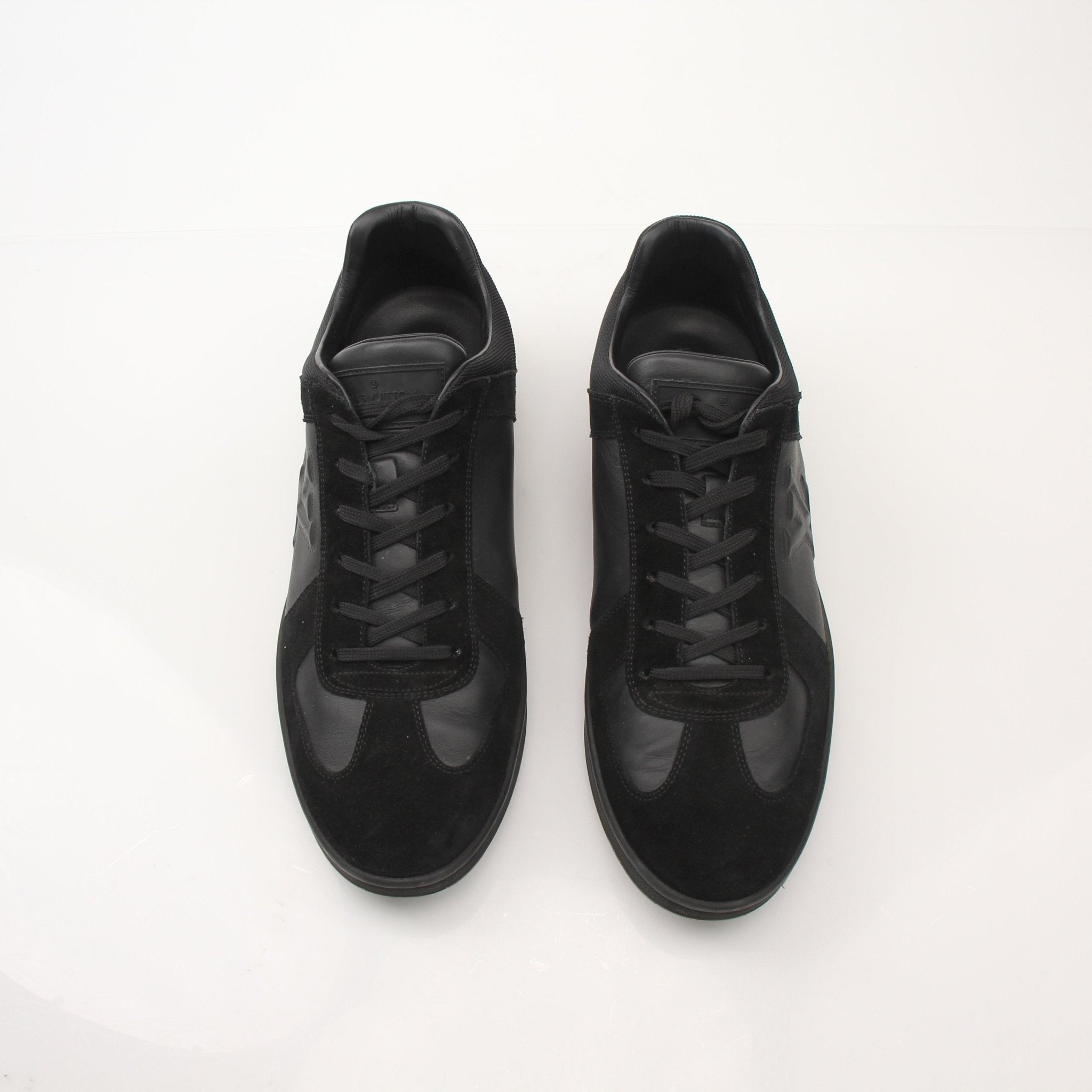 Black Louis Vuitton low top sneakers by Gold & Beyond, featuring sleek design and stylish laces on a clean background.