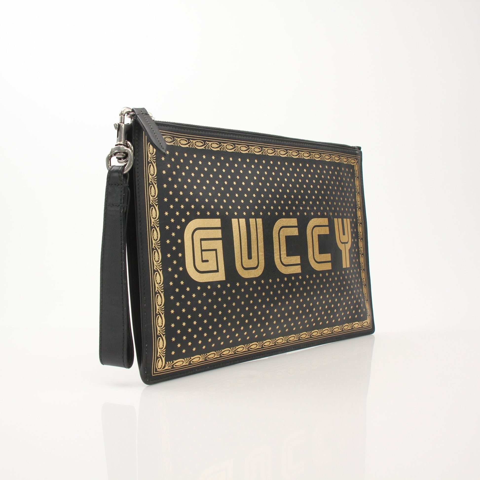 Gucci x SEGA black clutch handbag with gold accents, featuring a sleek design and gaming-inspired details.