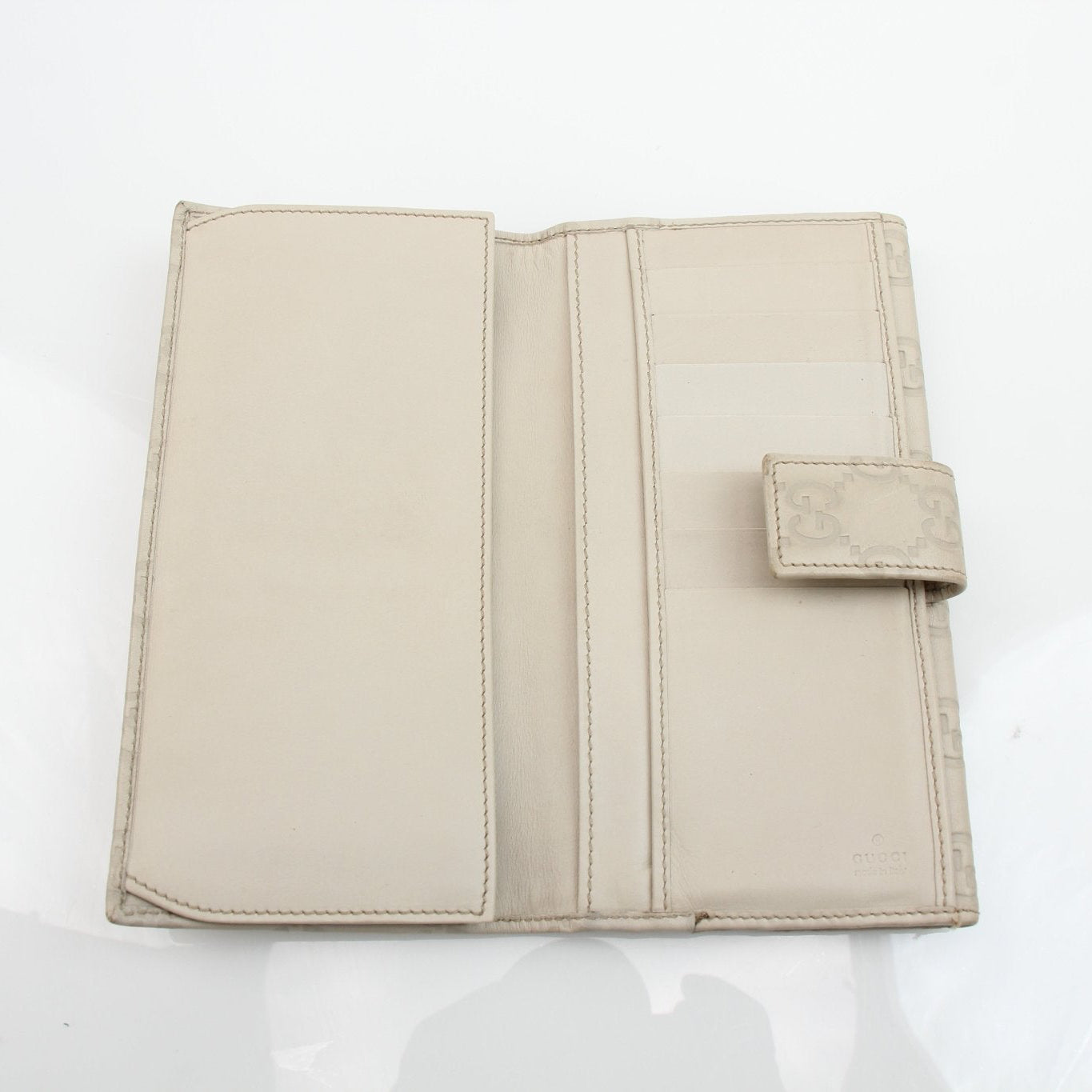 Beige Gucci Guccissima wallet with gold accents, featuring signature leather pattern and multiple card slots, by Gold & Beyond.