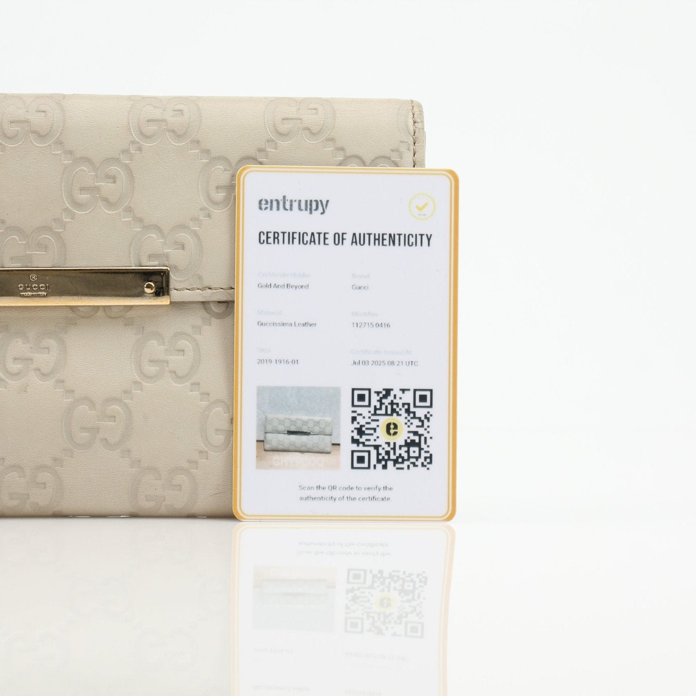 Gucci beige Guccissima wallet with signature pattern and leather trim, showcasing the elegant design and compact size.
