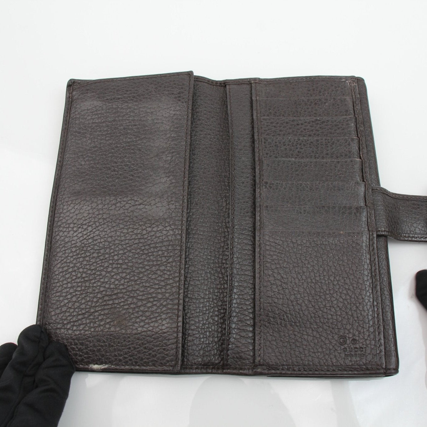 Gucci brown Eclipse wallet by Gold & Beyond, featuring a sleek leather design with gold-tone accents and multiple card slots.