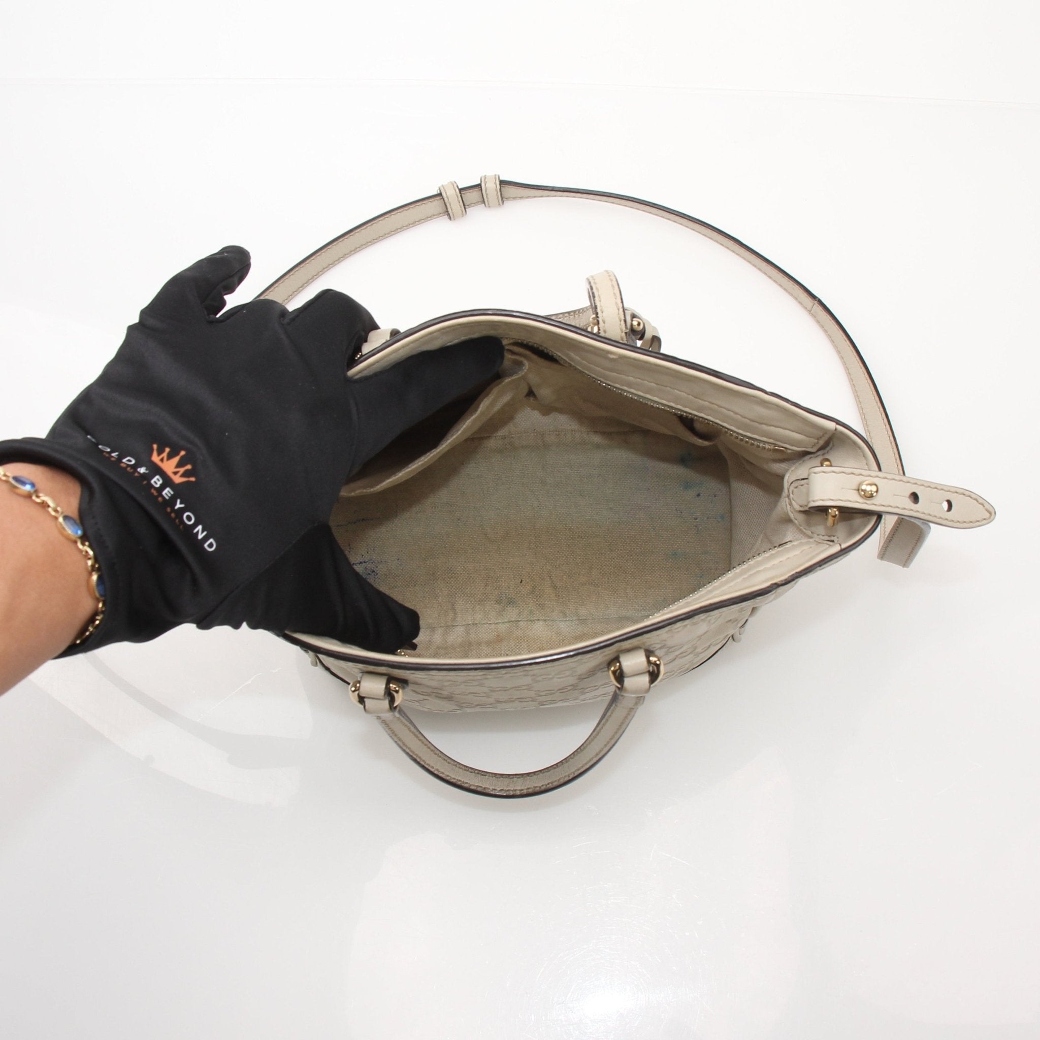 Gucci beige Bree tote handbag with gold accents, featuring a spacious design and stylish leather handles.