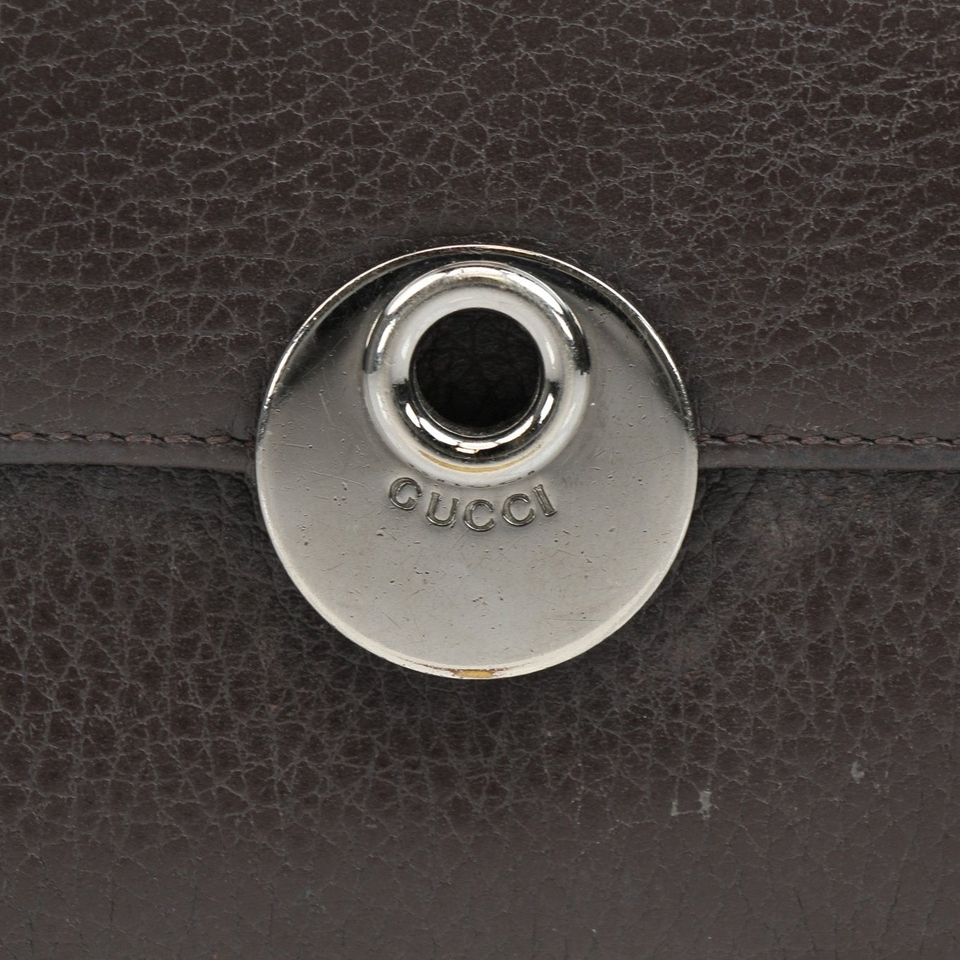 Gucci brown eclipse wallet with gold accents, showcasing sleek leather design and compact size for everyday use.