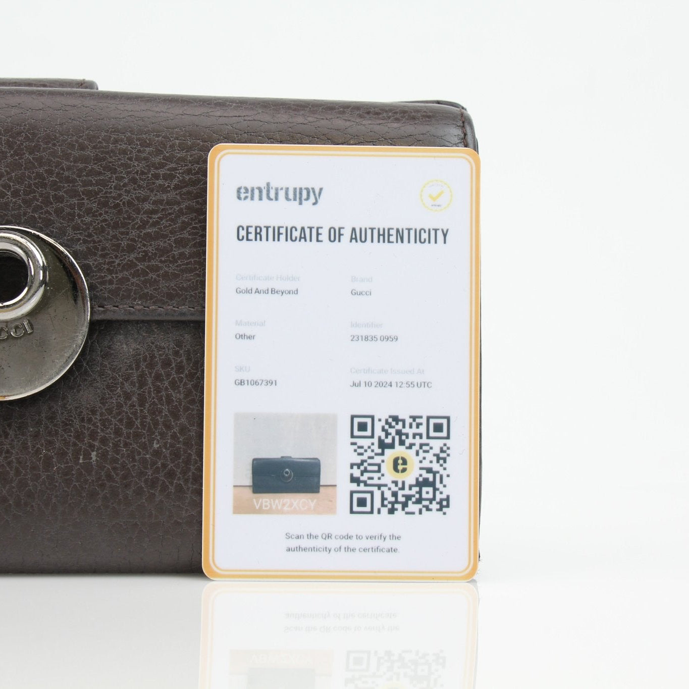 Gucci brown eclipse wallet with gold accents, crafted from leather, featuring multiple card slots and a sleek compact design.