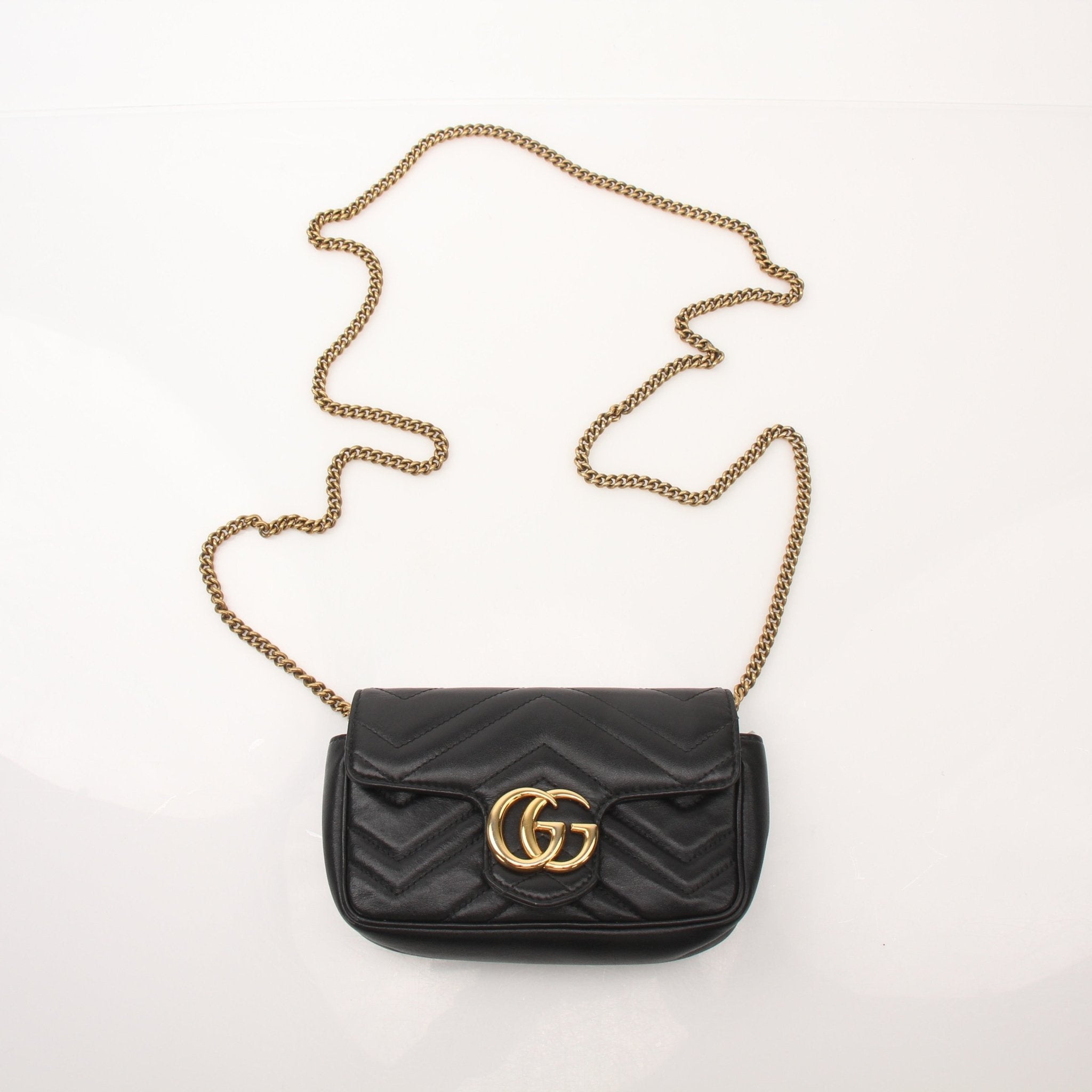 Gucci Calfskin Matelassé GG Marmont Super Mini Shoulder Bag with chain strap, black quilted leather, and gold-tone hardware.