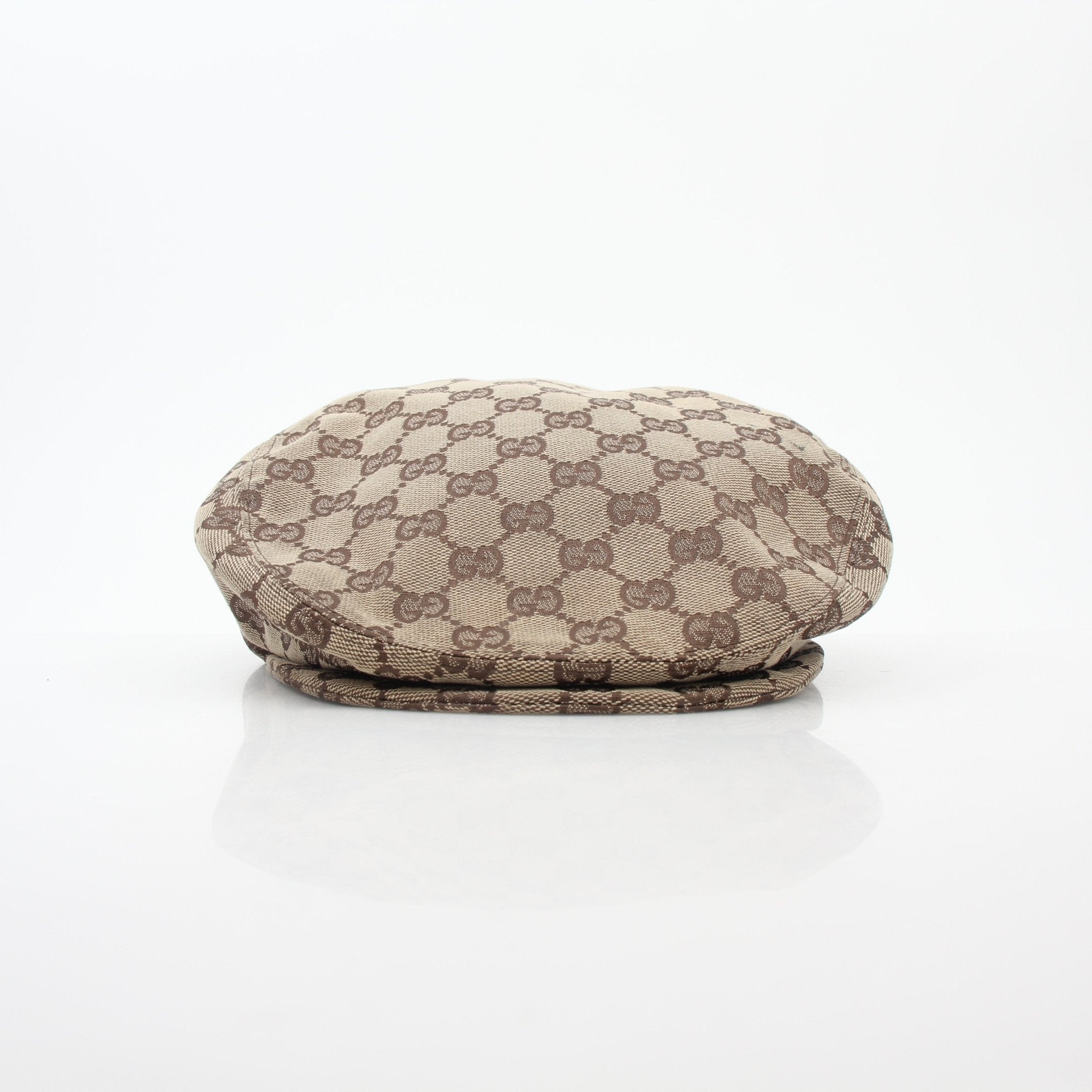 Gucci beige and brown GG canvas flat cap, stylish accessory with classic design, shown on a plain background.