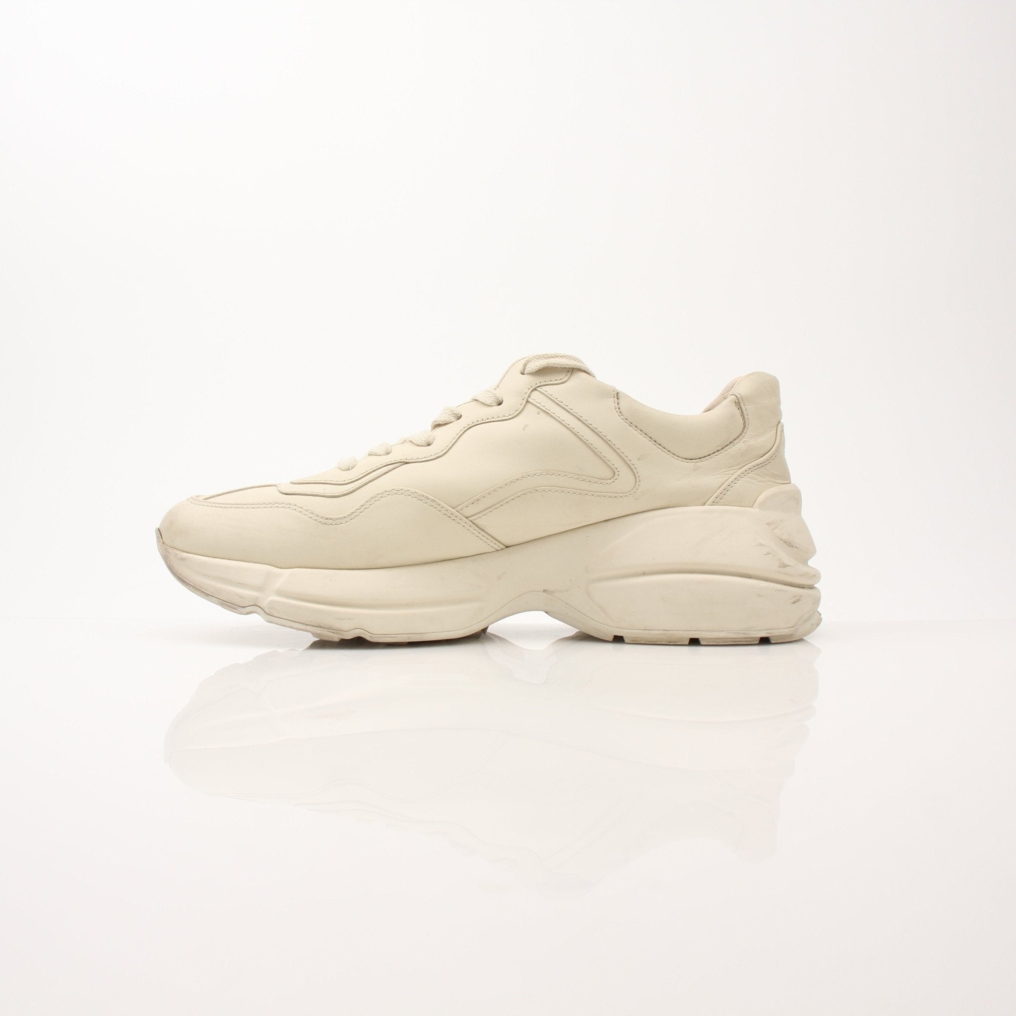 Gold & Beyond Gucci Women’s Rhyton Strawberry Sneakers showing white shoes with red strawberry embroidery and chunky rubber soles.