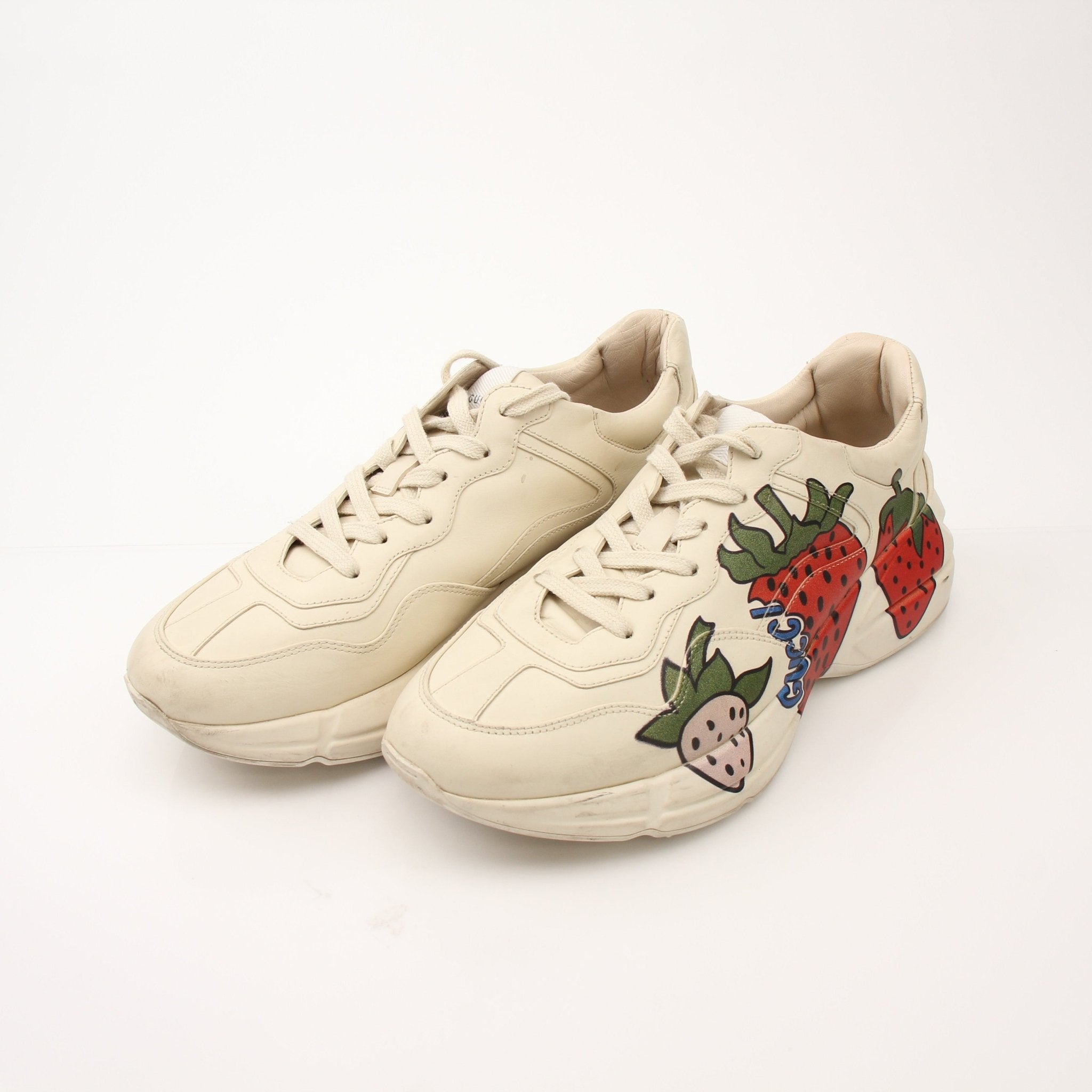 Gucci Women’s Rhyton Strawberry Sneakers with white leather and red strawberry details, casual shoes by Gold & Beyond.