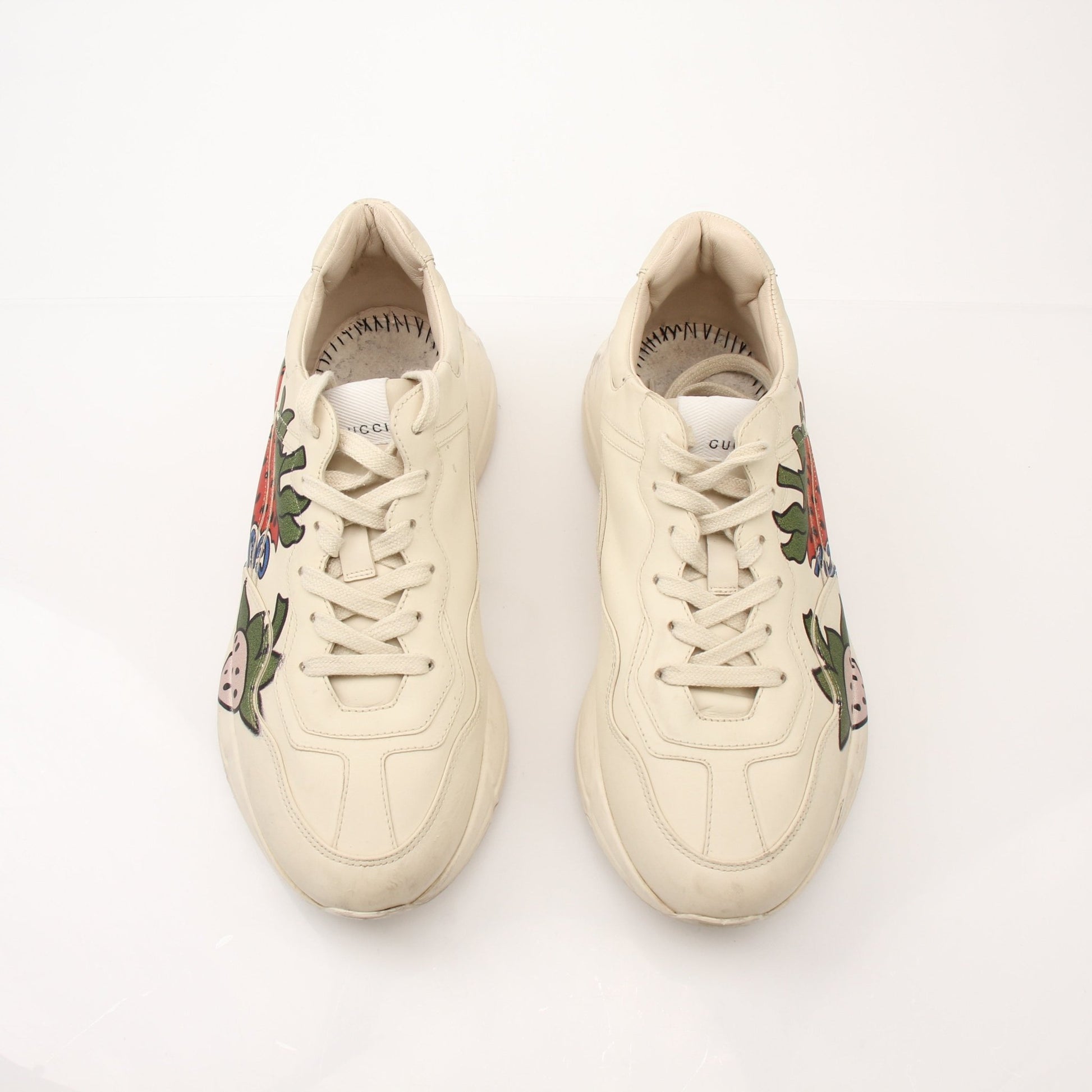 Gucci Women's Rhyton Strawberry Sneakers featuring white canvas with red strawberry embroidery and rubber soles.