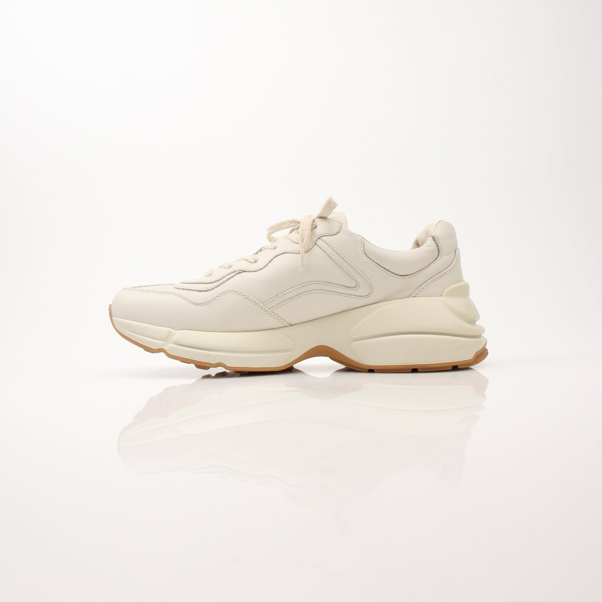 Gucci men's Rhyton Web Print sneakers with white leather, green and red web accents, and chunky rubber soles.