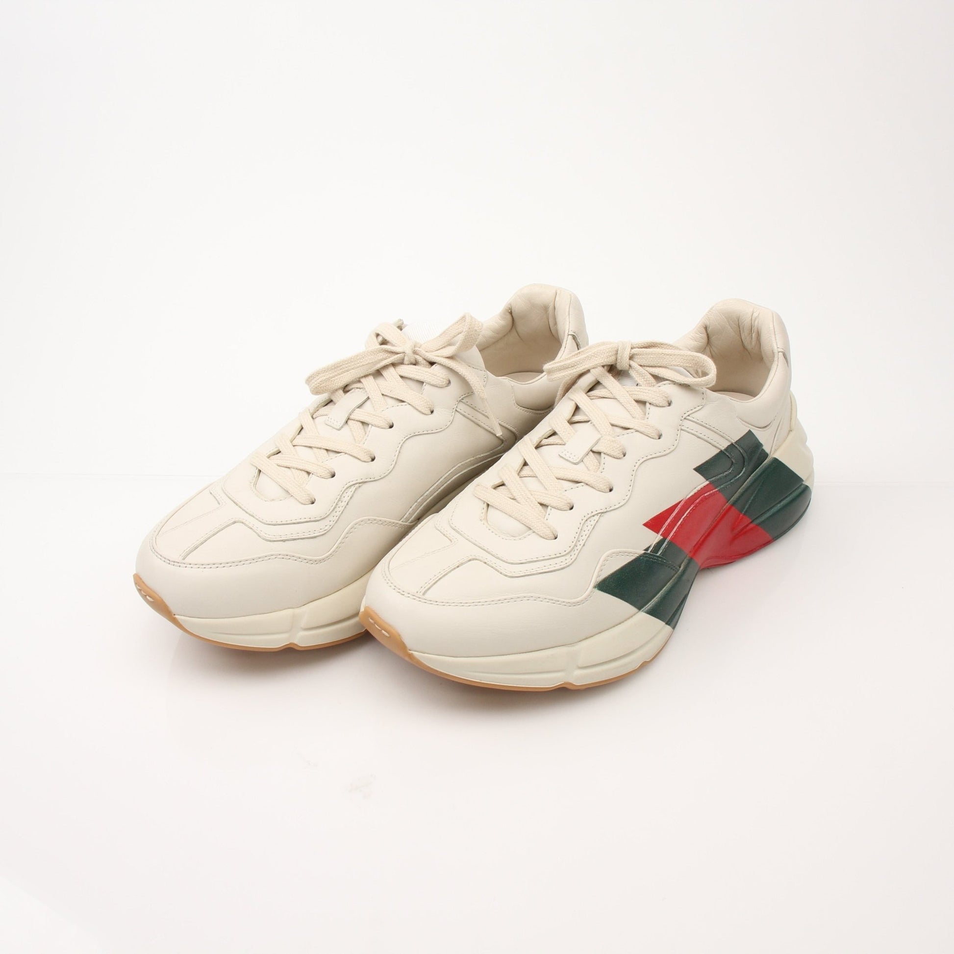 Gucci Men’s Rhyton Web Print Sneakers with white sole, black leather accents, and signature web detailing, showcasing stylish footwear.