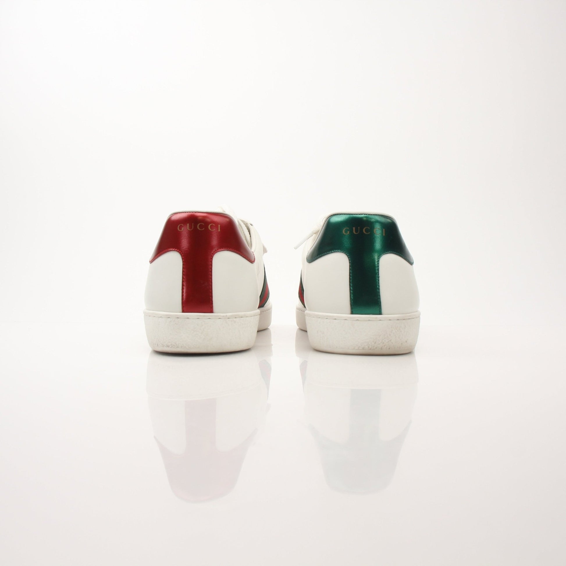 Gold & Beyond Gucci men's GG Apple sneakers featuring white leather uppers, green and red striped accents, and rubber soles.