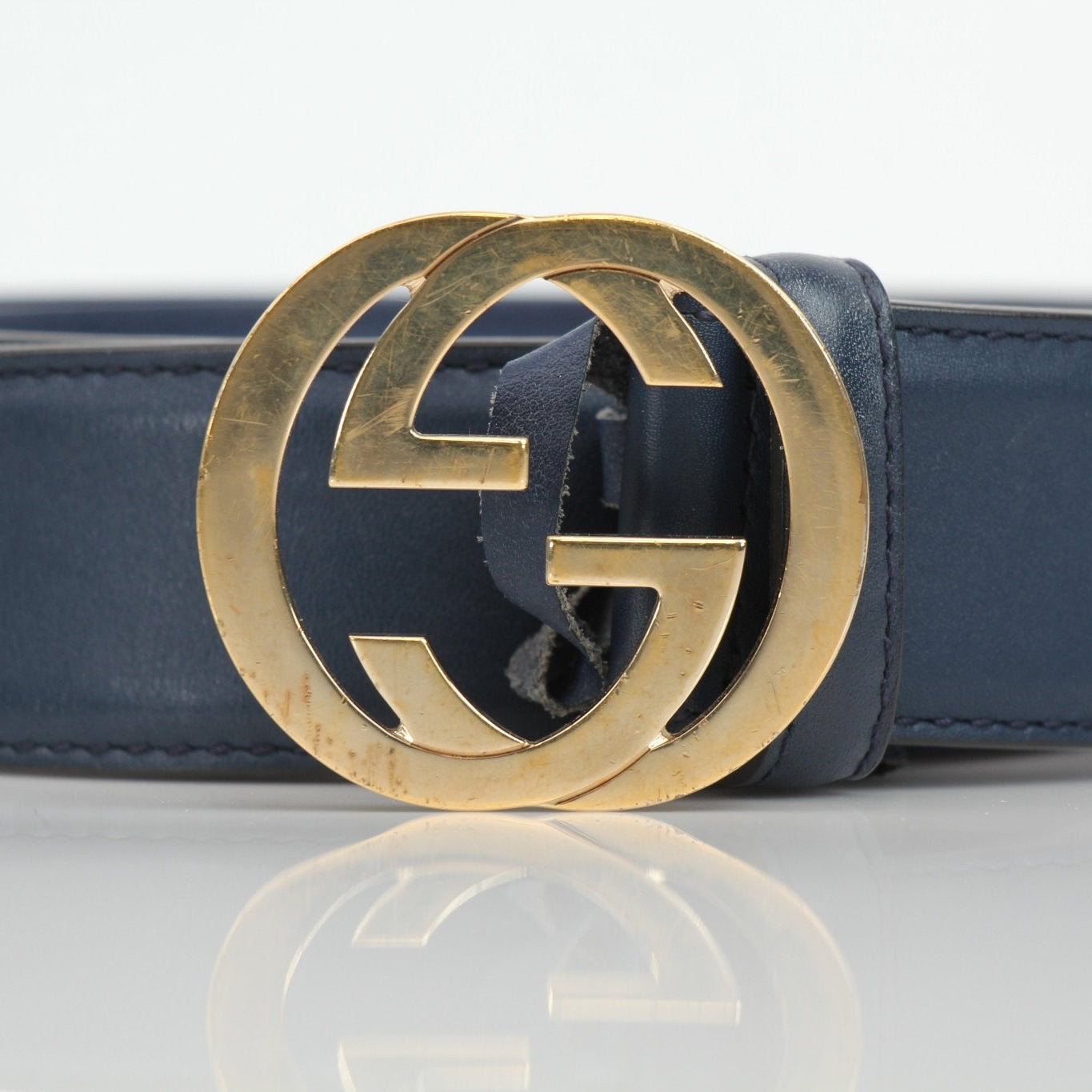Gucci navy Interlocking GG belt with gold buckle, stylish accessory for men and women, featuring signature designer logo.
