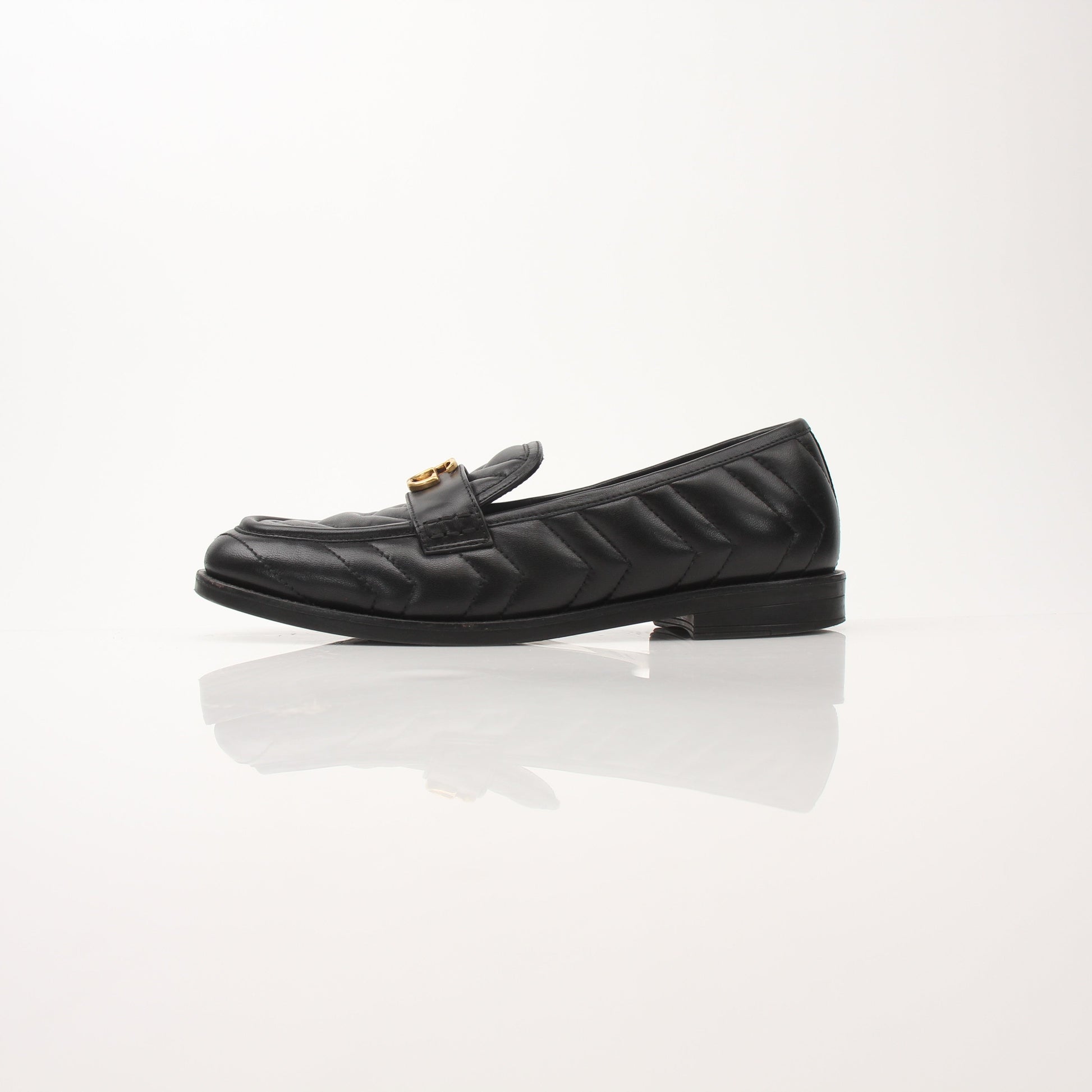 Gold & Beyond Gucci women’s Double G loafers, stylish leather shoes with gold hardware, displayed on a neutral background.