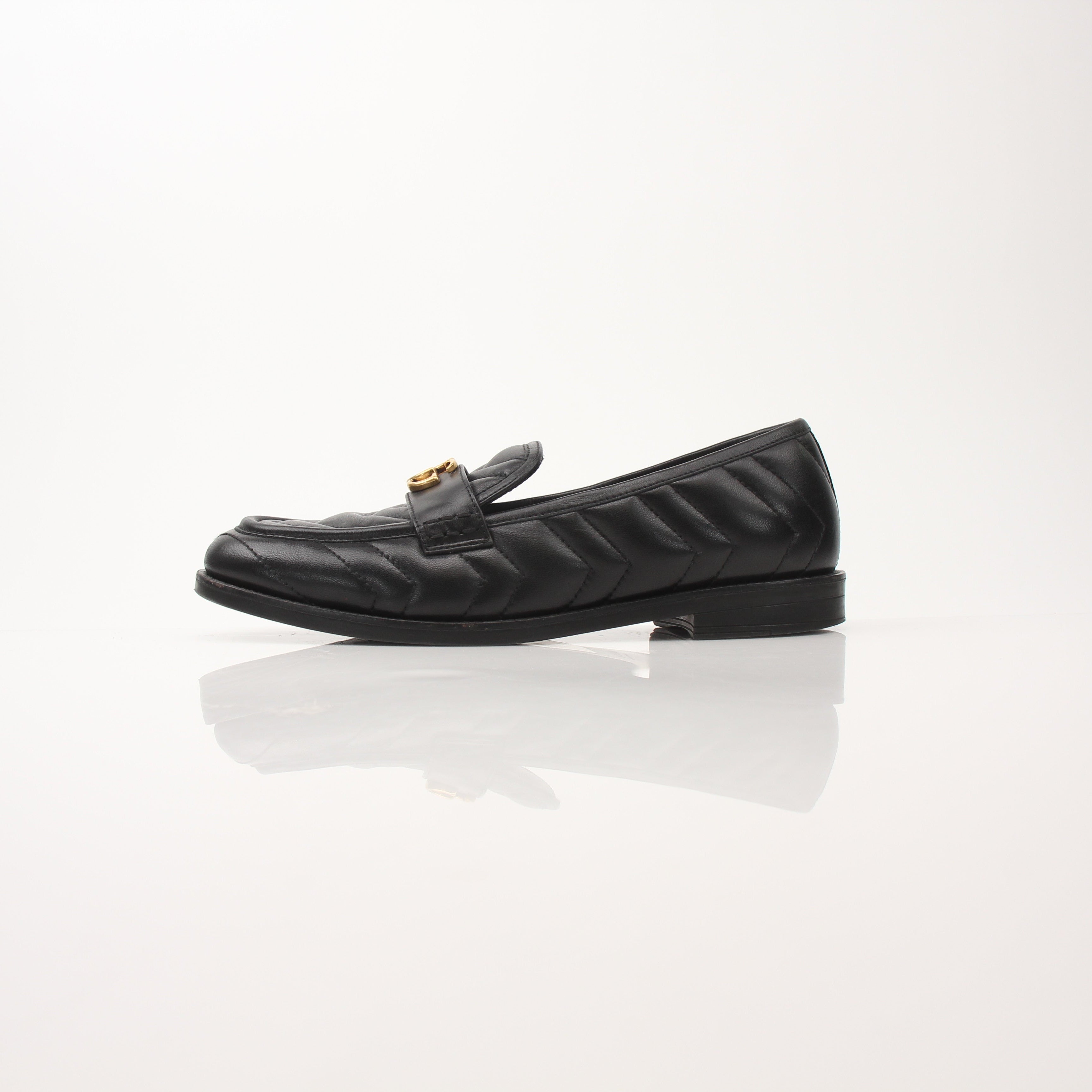 Gold & Beyond Gucci women’s Double G loafers, stylish leather shoes with gold hardware, displayed on a neutral background.