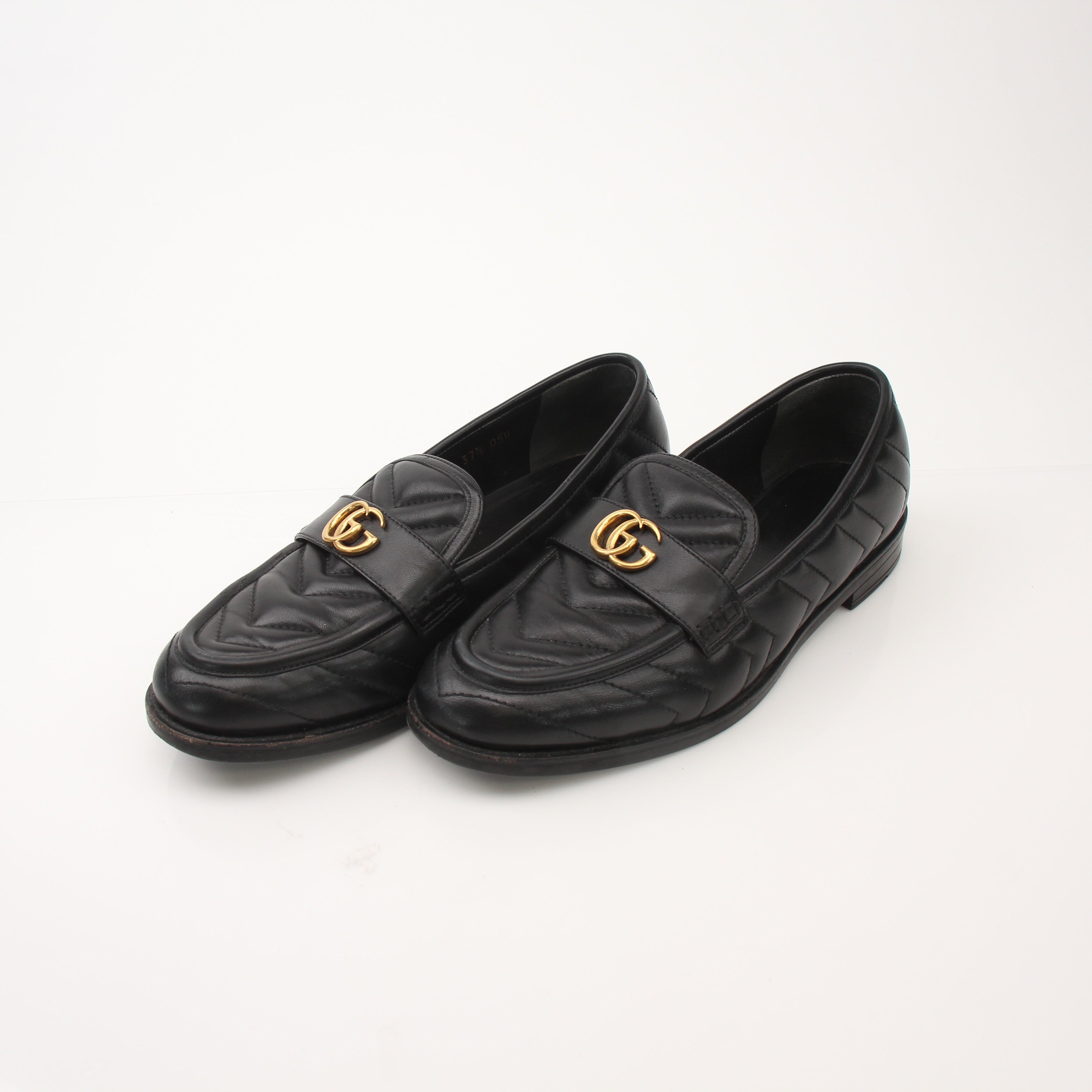 Gold & Beyond Gucci women's double G loafers shoes with sleek leather design and signature hardware detail.