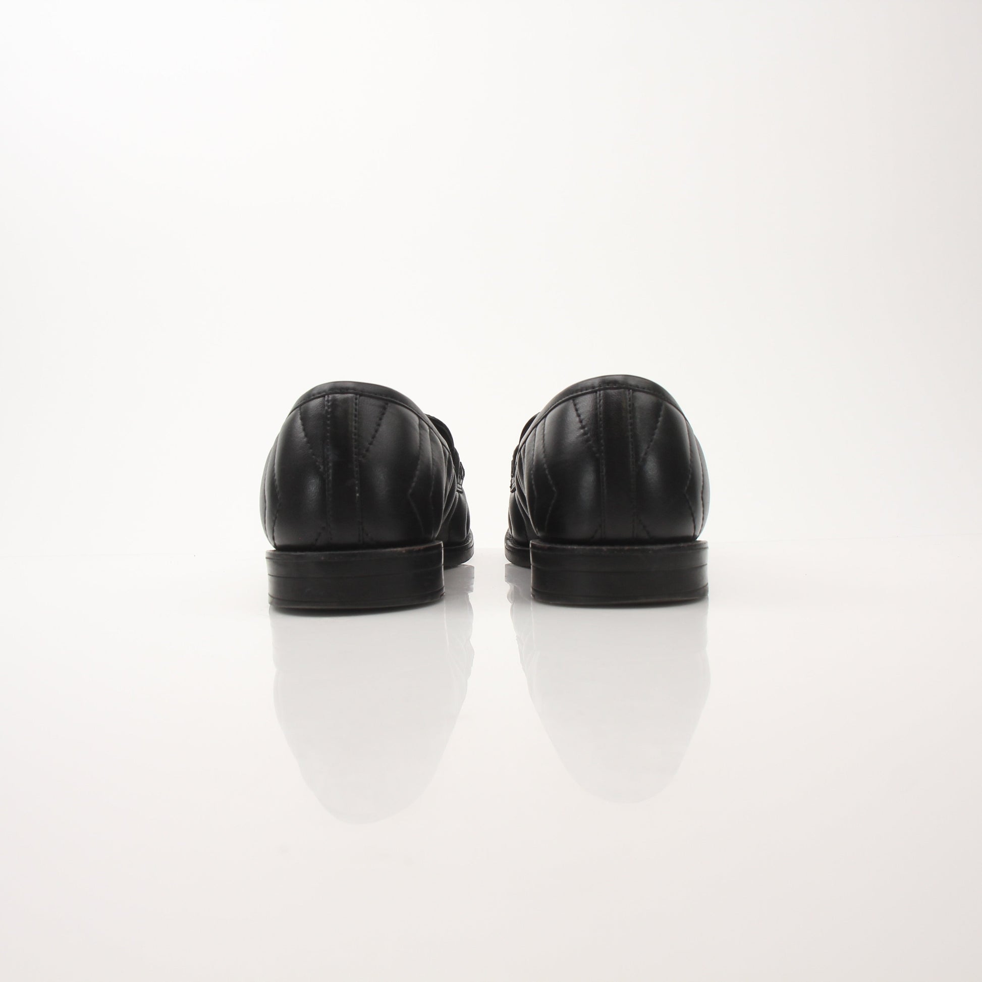 Gold & Beyond Gucci women’s double G loafers, stylish leather shoes with signature logo detail, on a neutral background.