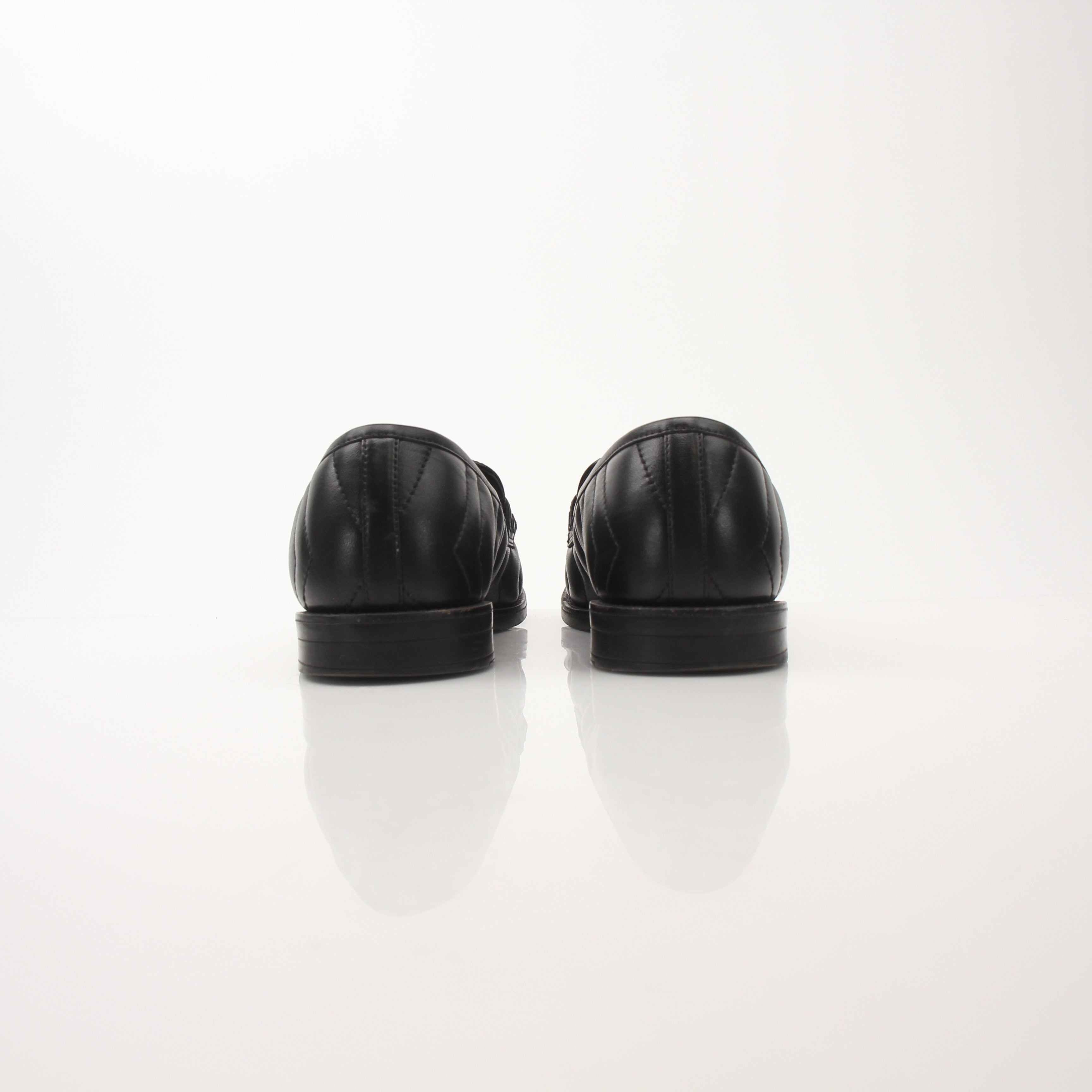 Gold & Beyond Gucci women’s double G loafers, stylish leather shoes with signature logo detail, on a neutral background.
