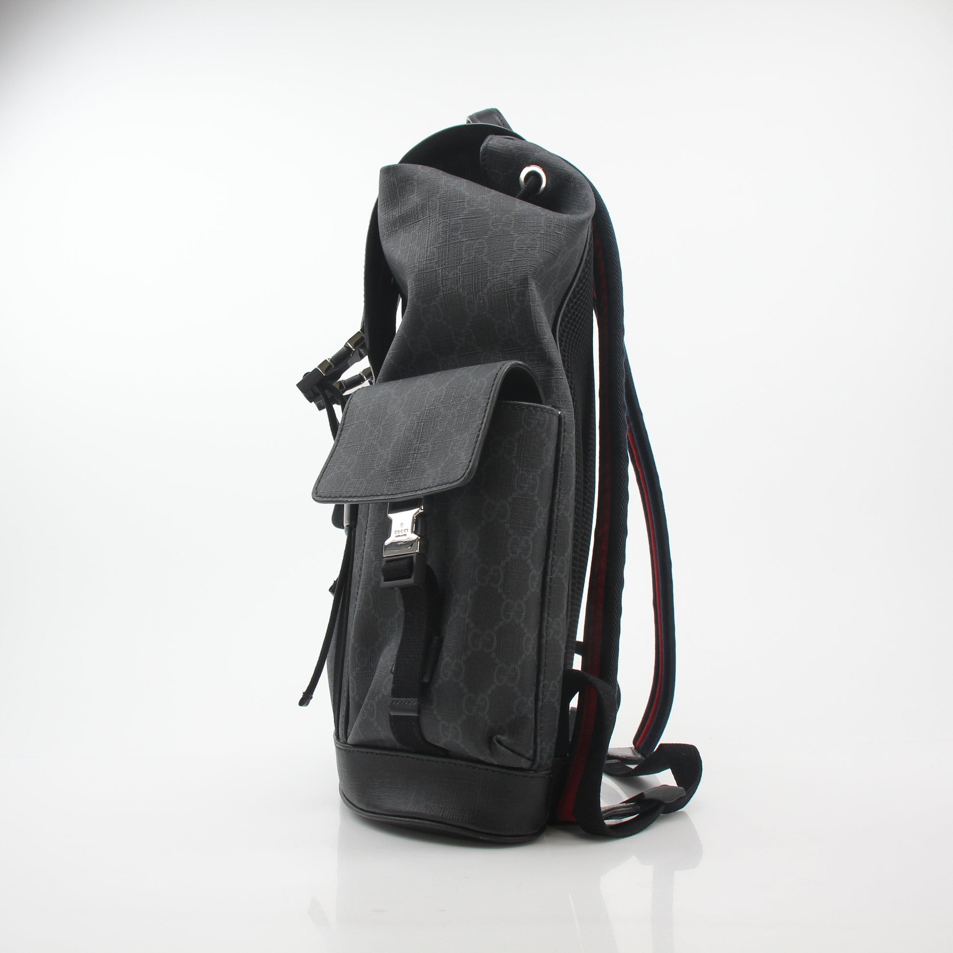Gucci Black GG Supreme Lark Backpack, a stylish travel bag with the iconic pattern and leather straps, on a plain background.