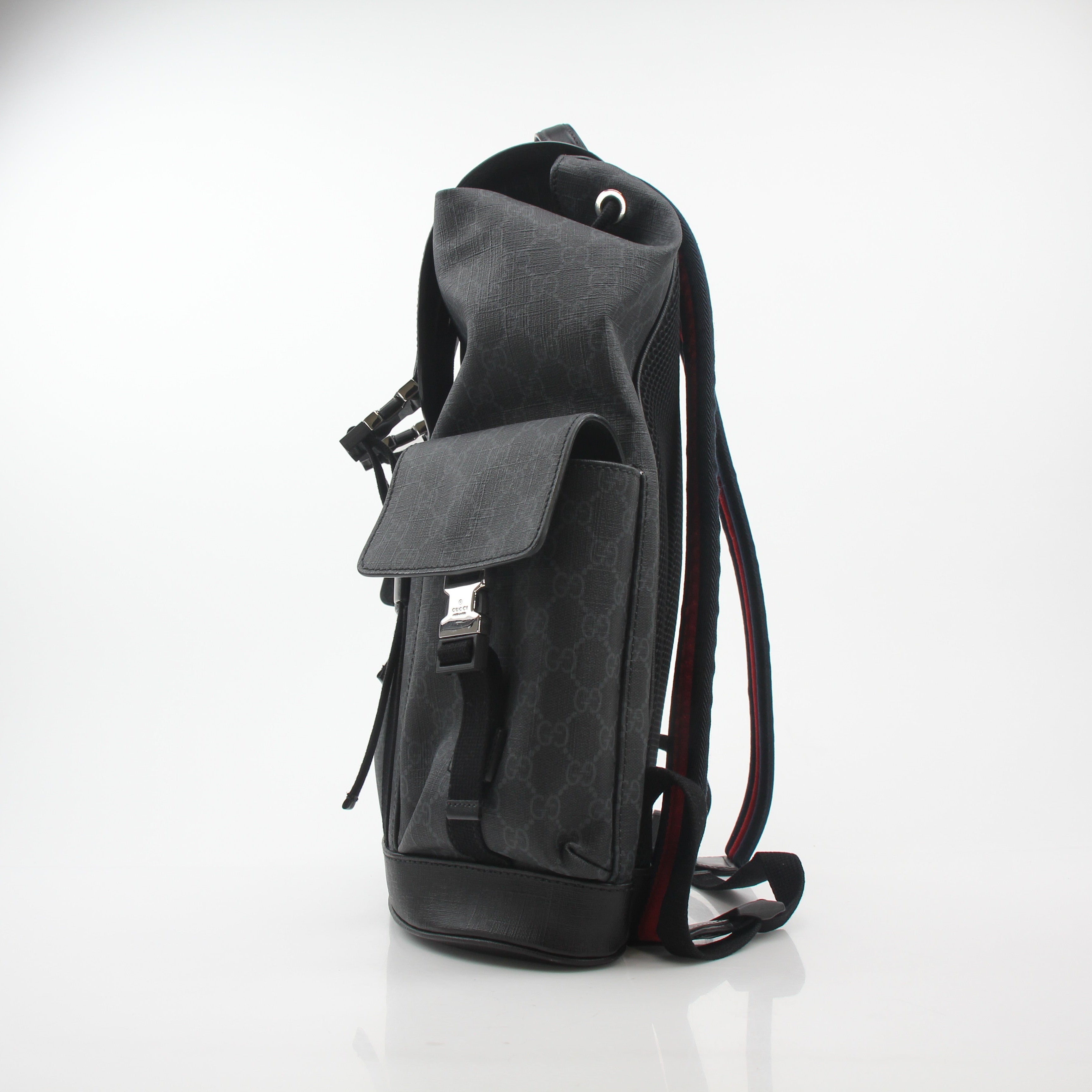 Gucci Black GG Supreme Lark Backpack, a stylish travel bag with the iconic pattern and leather straps, on a plain background.