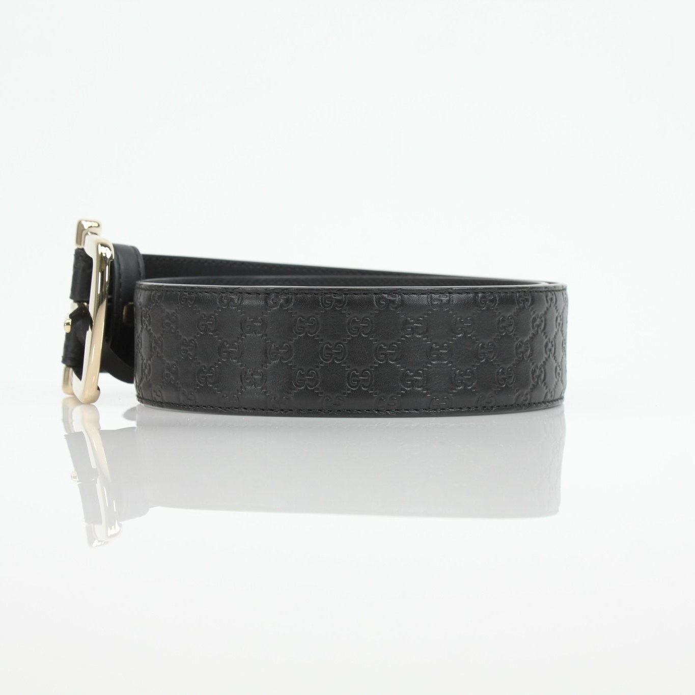 Black Gucci Guccissima belt with gold buckle, stylish accessory for men and women, featuring signature Gucci pattern.