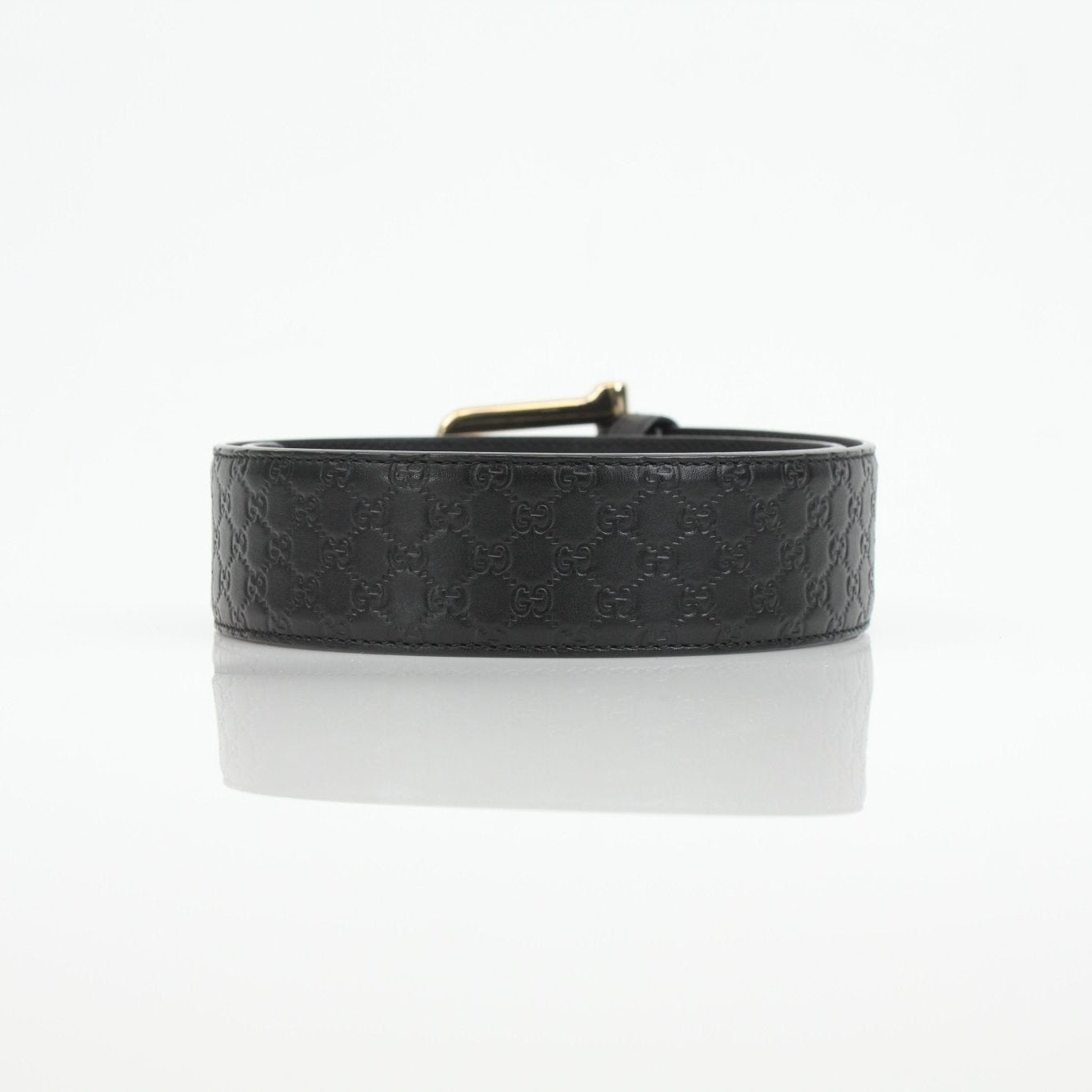 Black Gucci Guccissima belt with gold buckle, stylish accessory featuring iconic monogram pattern and sleek design.