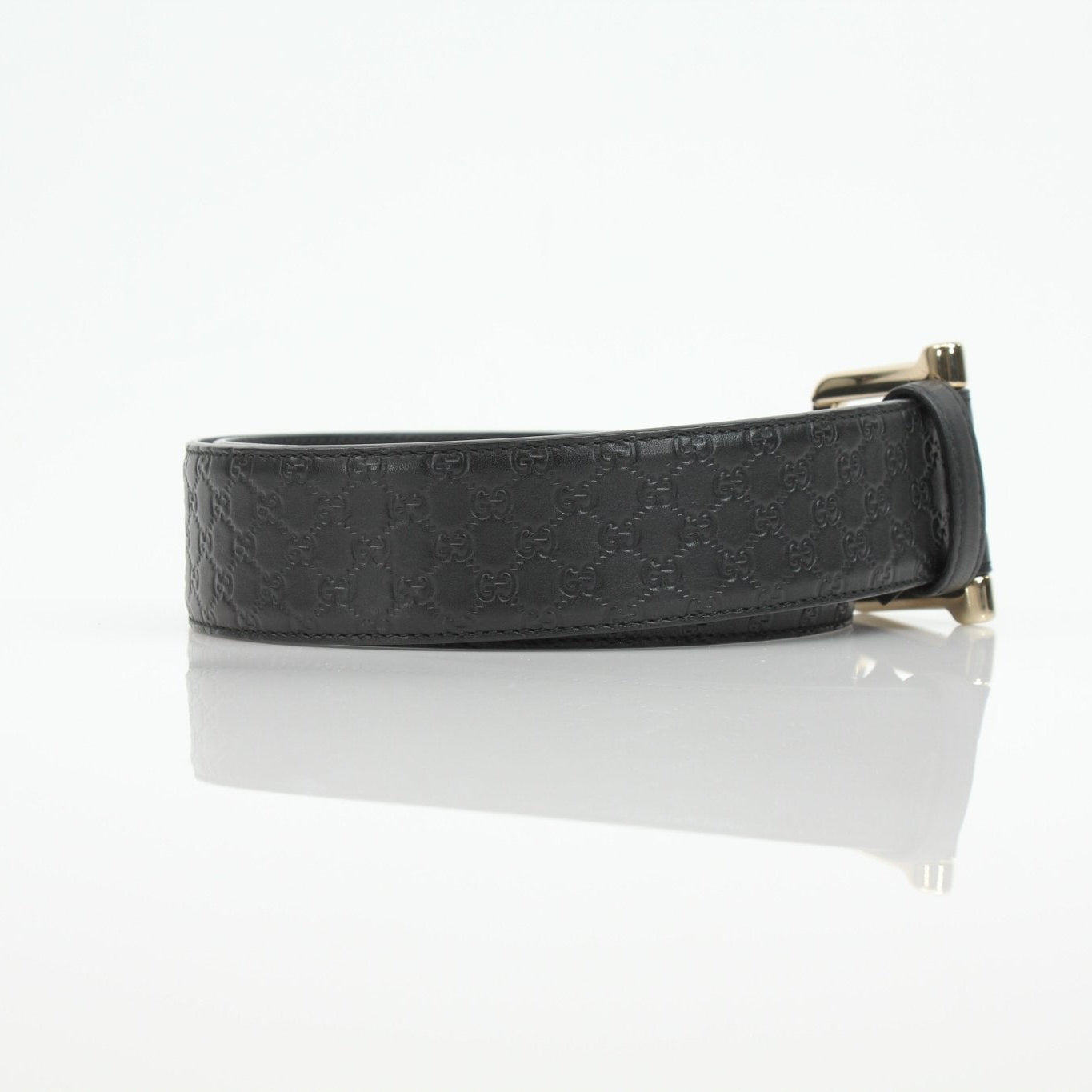 Black Gucci Guccissima belt with gold buckle, luxury accessories from Gold & Beyond, featuring signature monogram pattern.