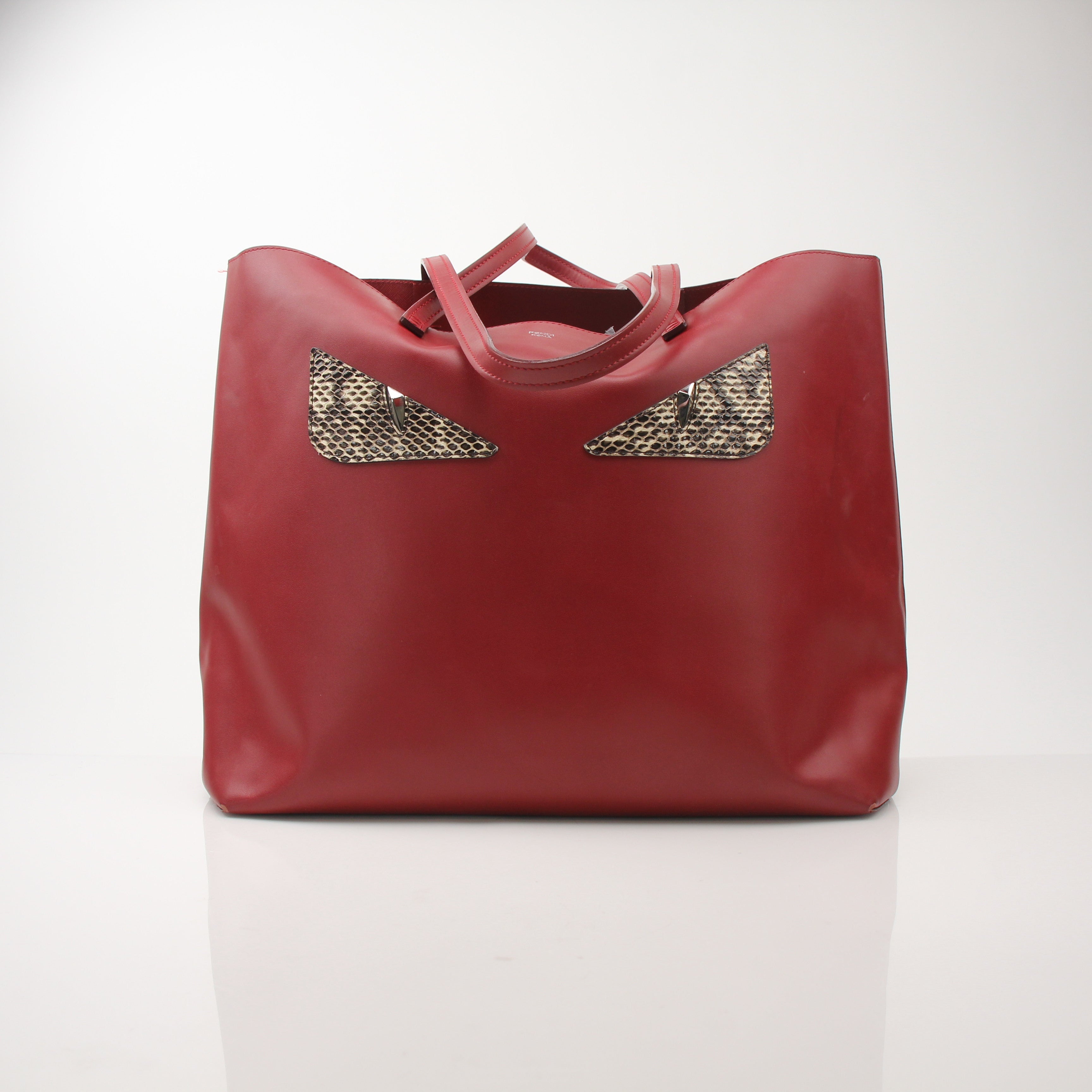 Red monster print Fendi handbag with roll tote design from Gold & Beyond, featuring bold graphic details and sturdy handles.