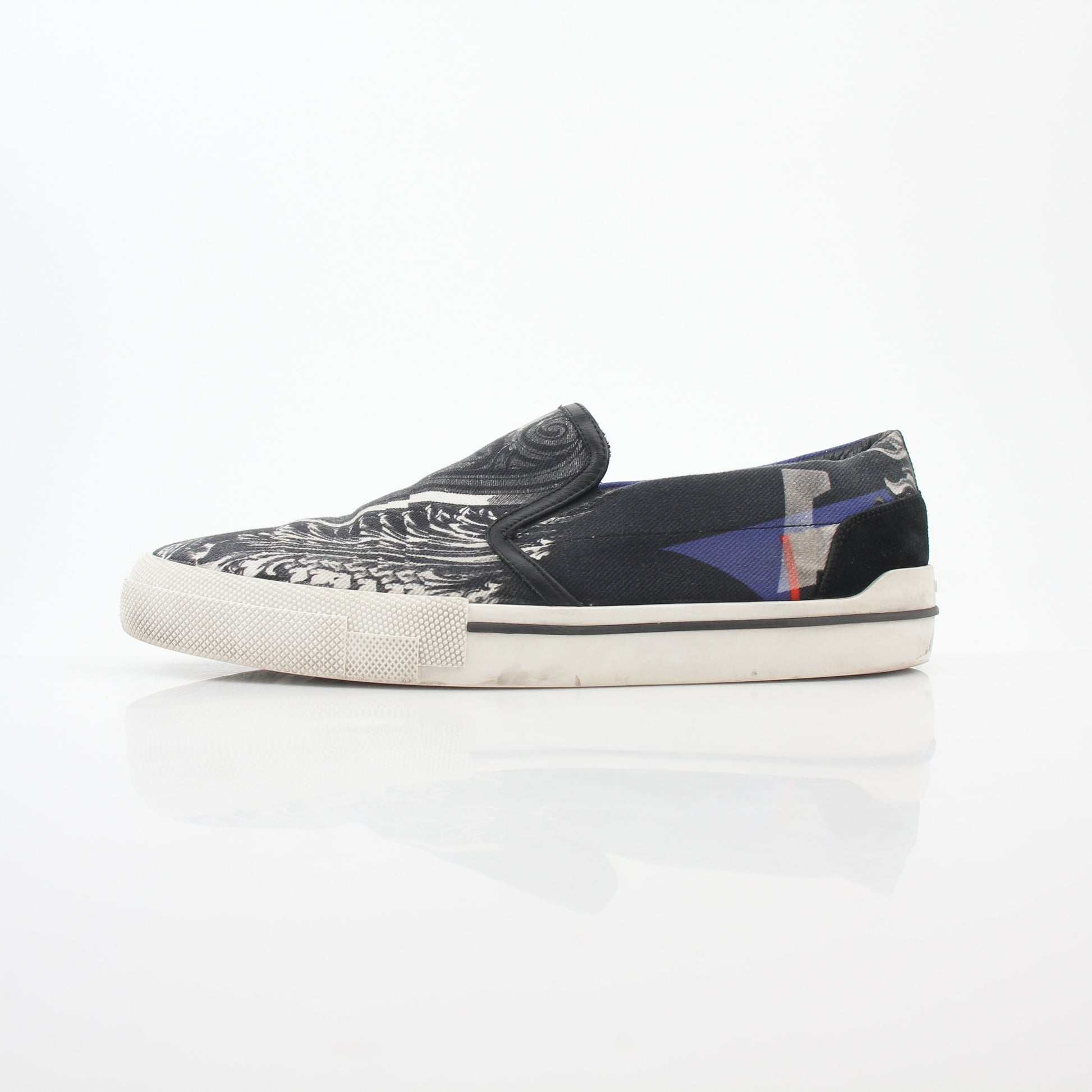 Versace men's graphic print canvas slip-on sneakers with bold design, featuring black and white artwork and casual shoe style.