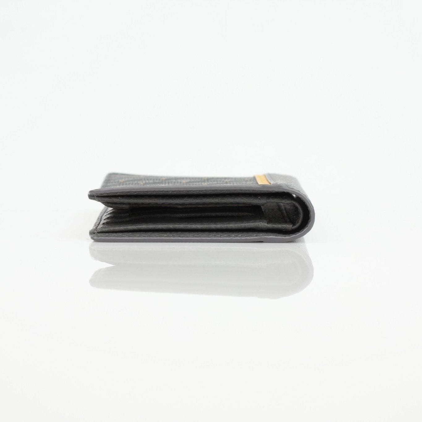 Gold & Beyond Faure Le Page Scale Canvas Wallet showing a compact black wallet with scale pattern and multiple card slots.
