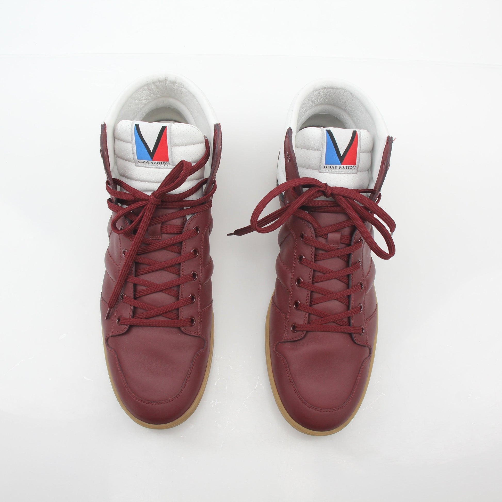 Louis Vuitton Burgundy Spitfire high-top sneakers by Gold & Beyond, featuring red and brown leather with brand logo details.