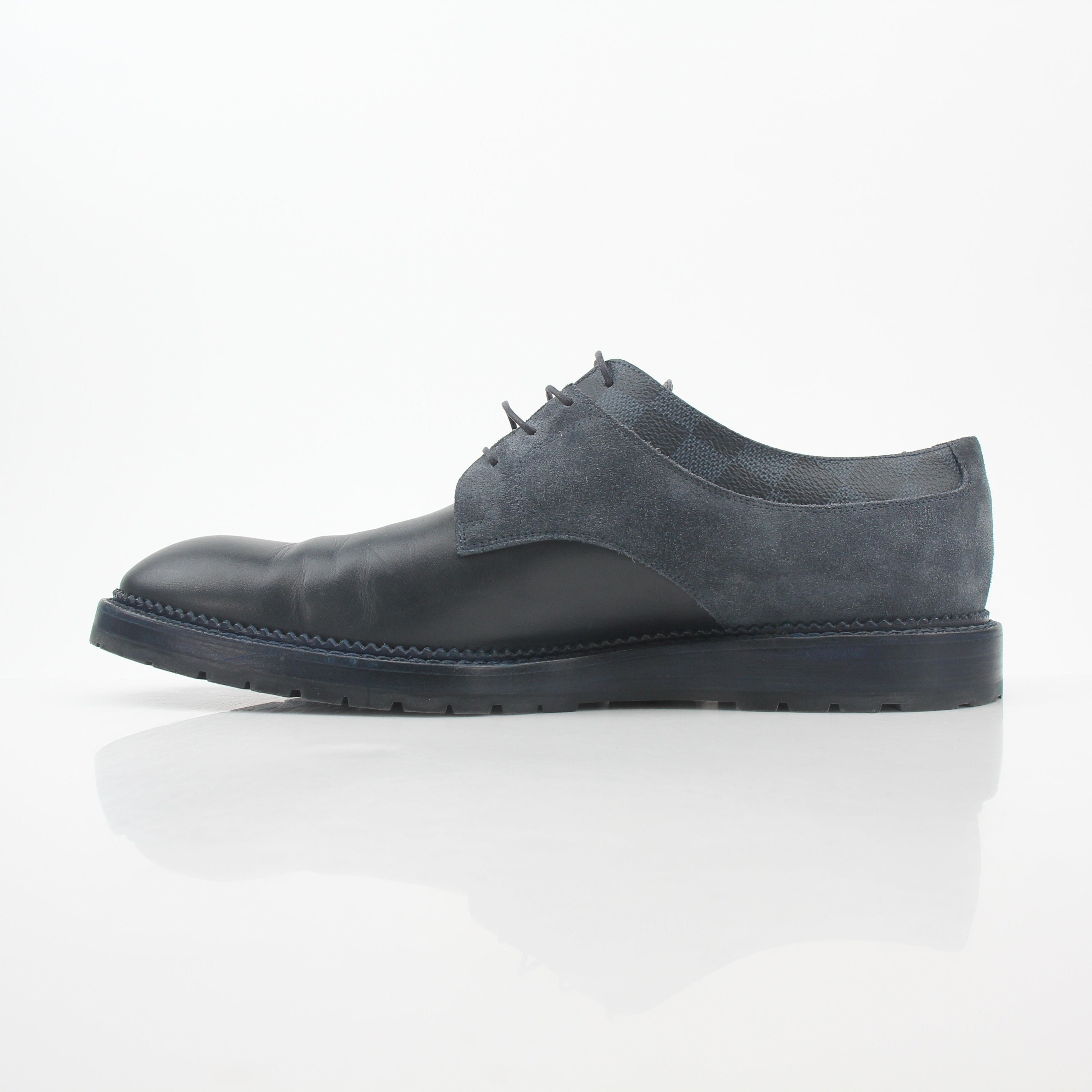 Louis Vuitton black and charcoal Damier suede derby shoes with leather soles, displayed on a neutral background.