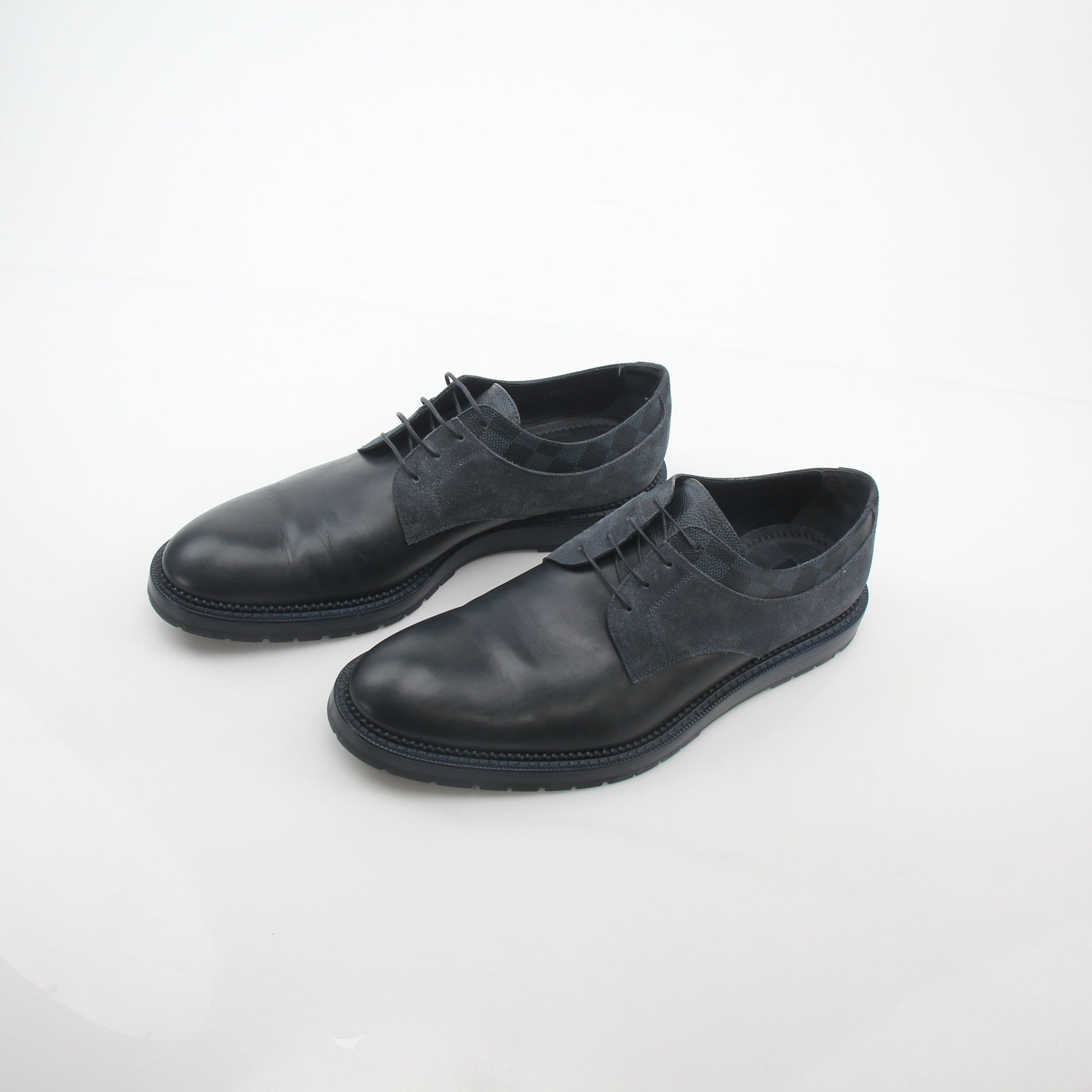 Louis Vuitton black and charcoal Damier suede Derby shoes with laces and sleek design, displayed on a neutral background.