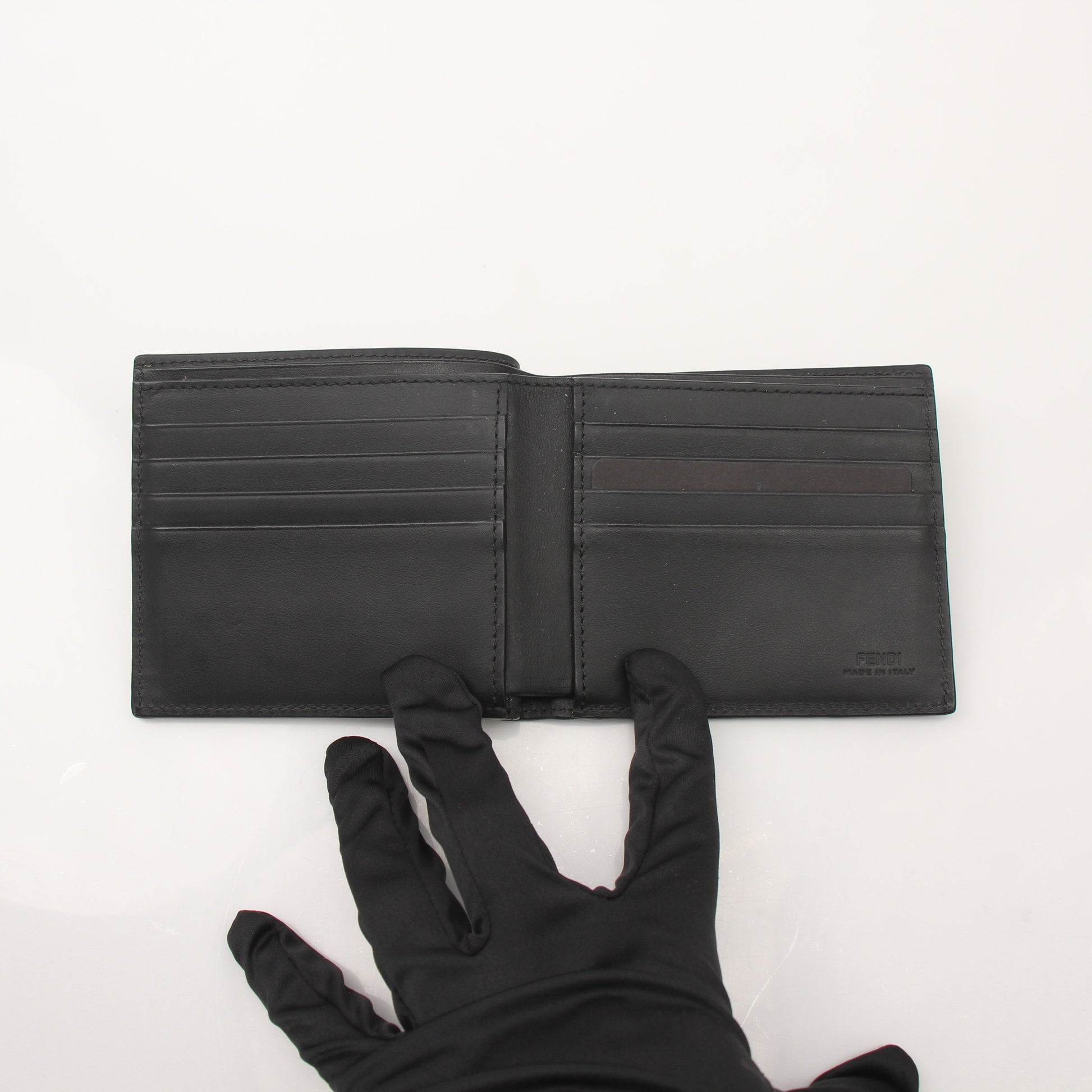 Fendi Vitello Century metal monster eyes bi-fold wallet with textured leather and gold-tone hardware, showcasing unique design details.