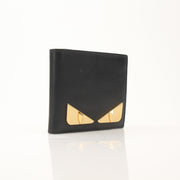 Fendi Vitello Century metal monster eyes bi-fold wallet with gold accents and textured leather detailing.