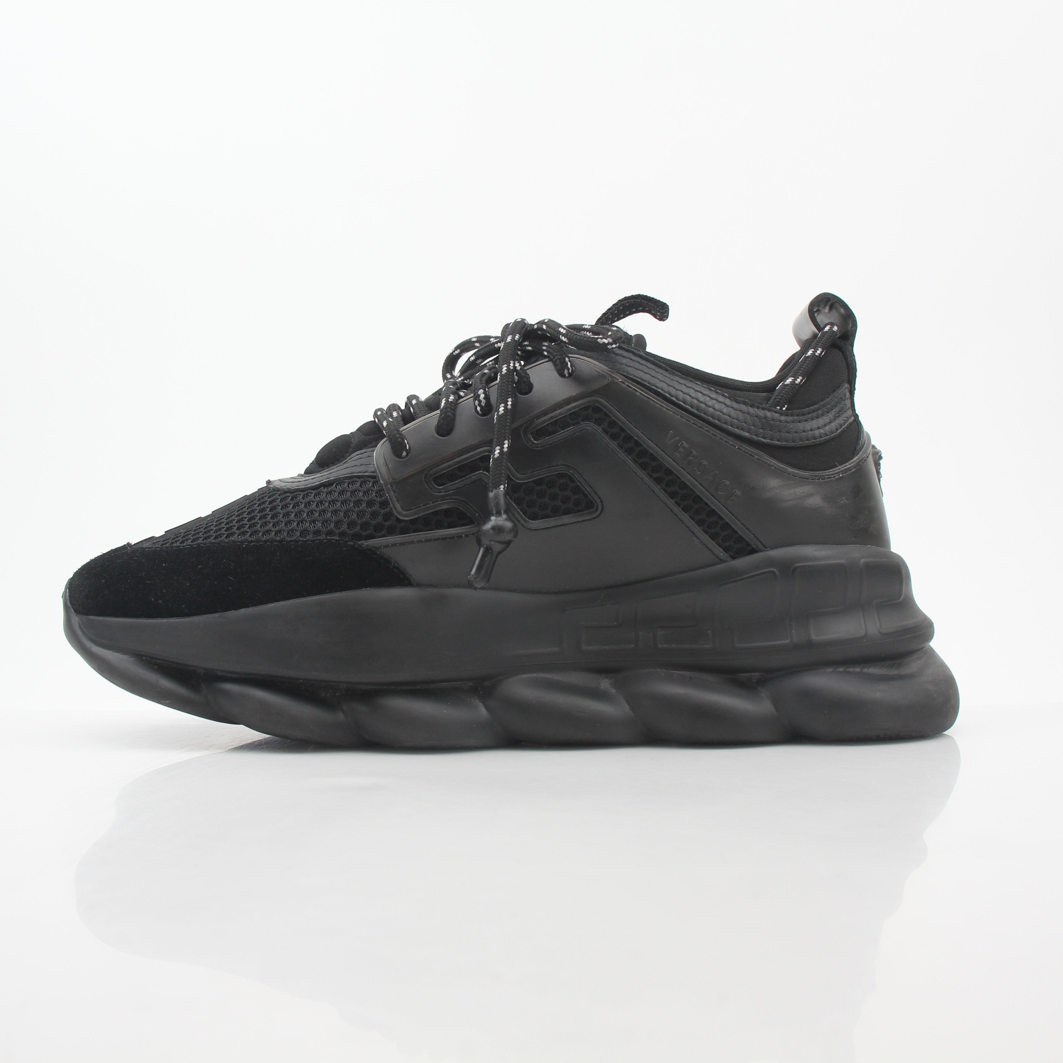 Black Chain Reaction sneakers by Versace featuring gold accents and stylish design, displayed on a white background.