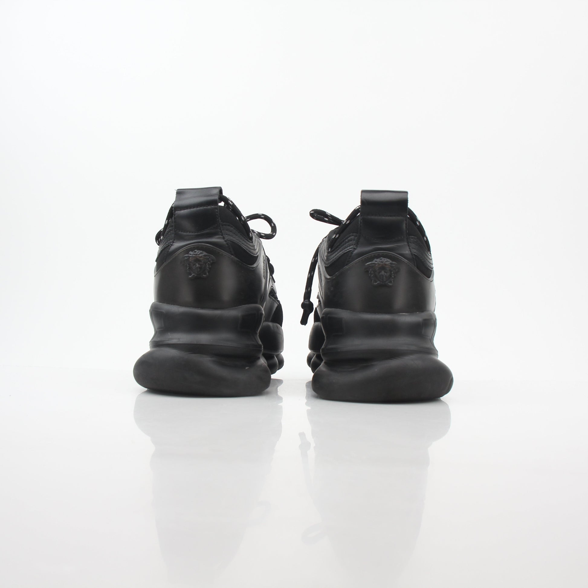 Versace Black Chain Reaction sneakers featuring bold chain details and stylish design, worn on feet with casual outfits.