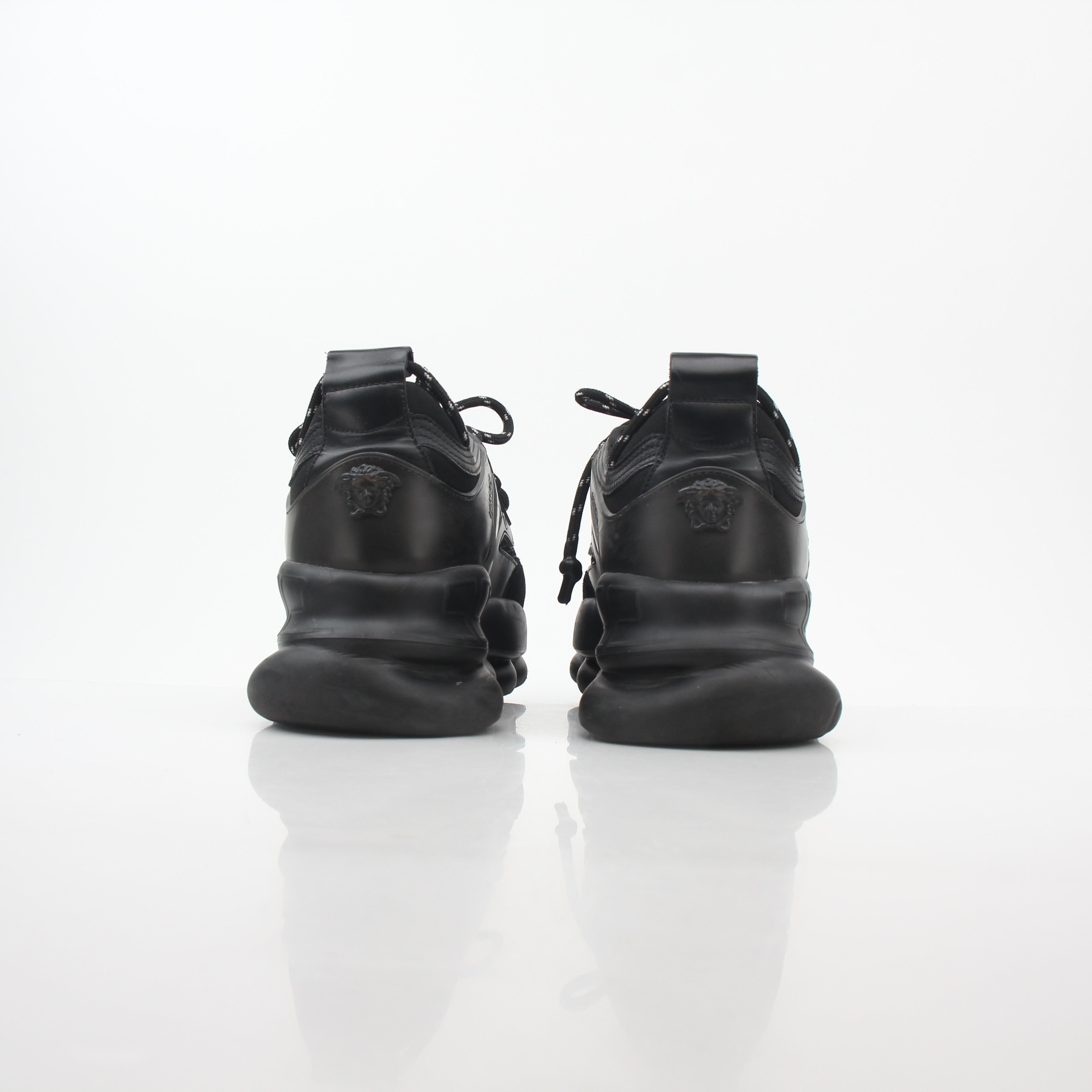 Versace Black Chain Reaction sneakers featuring bold chain details and stylish design, worn on feet with casual outfits.
