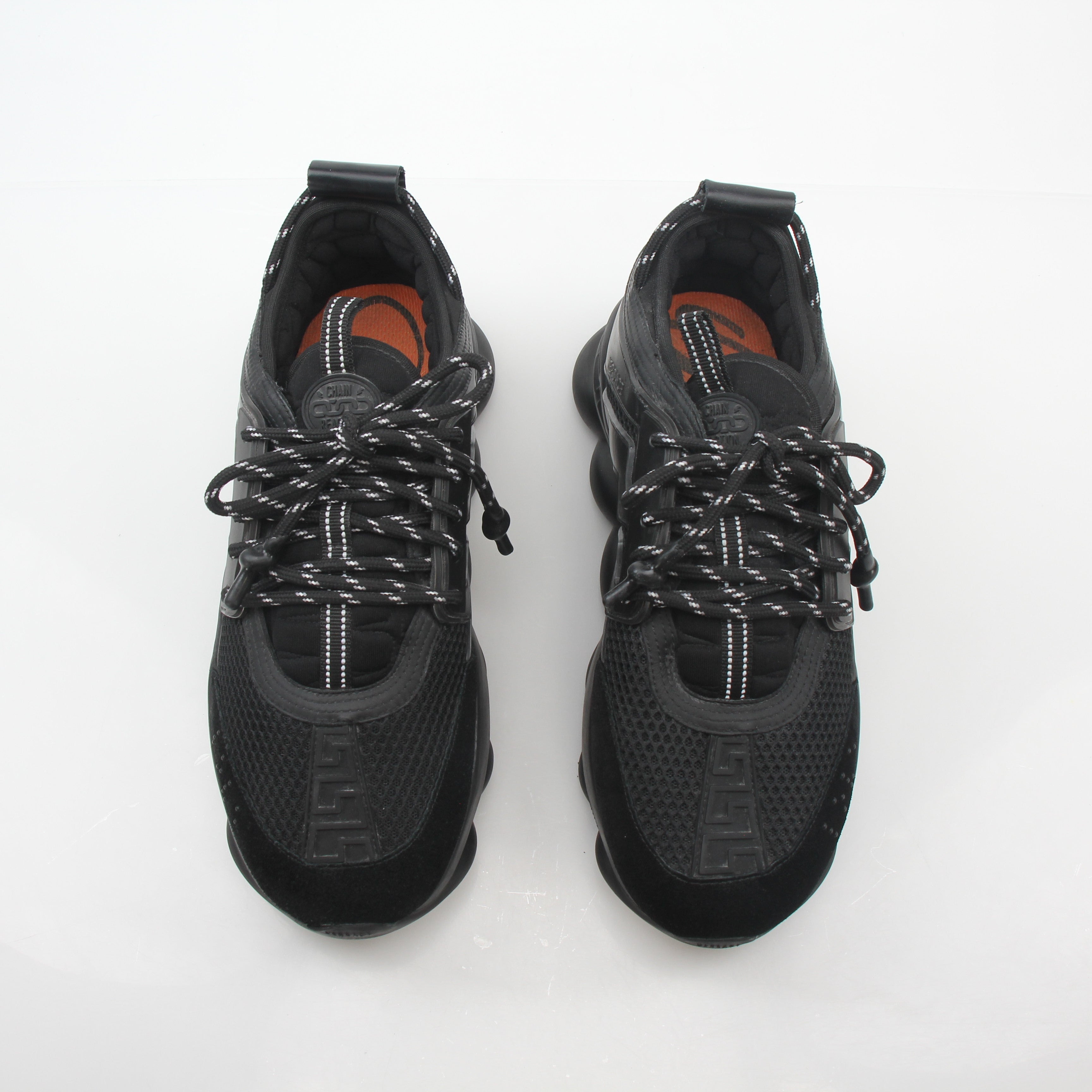 Versace Black Chain Reaction Sneakers with bold chain detail, black shoes, and stylish design by Gold & Beyond.