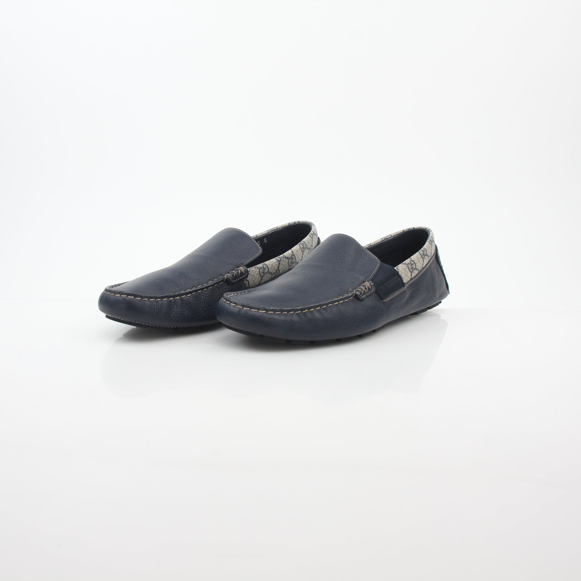 Gucci navy GG Supreme leather driver loafers, stylish men's shoes with classic branding and comfortable slip-on design.