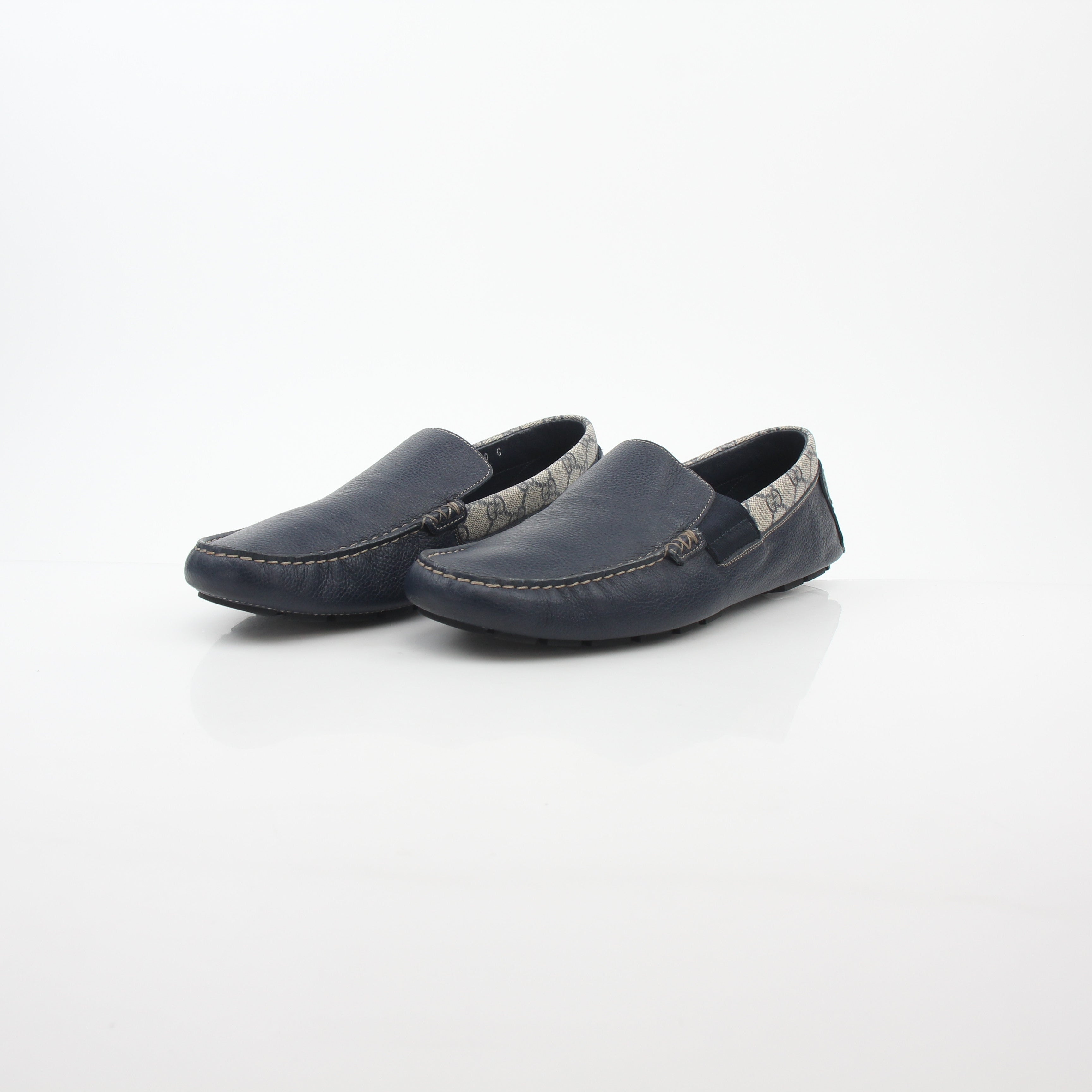 Gucci navy GG Supreme leather driver loafers, stylish men's shoes with classic branding and comfortable slip-on design.