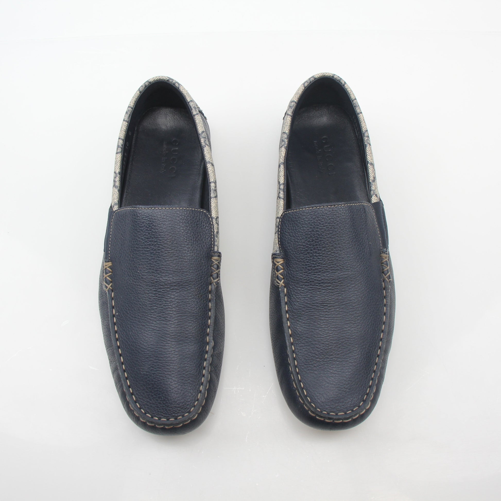 Gucci navy GG Supreme leather driver loafers with classic design and slip-on style, displayed on a neutral background.