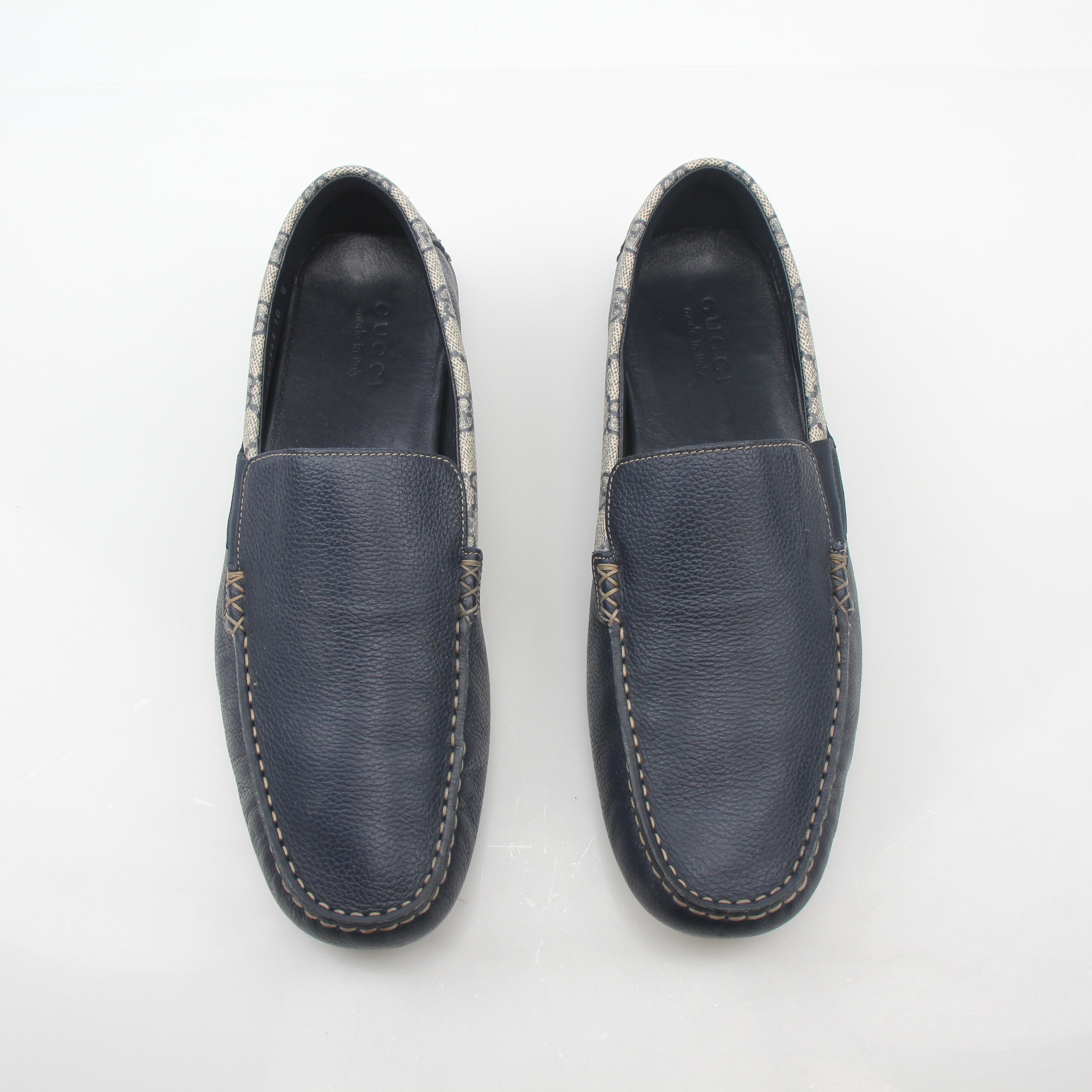 Gucci navy GG Supreme leather driver loafers with classic design and slip-on style, displayed on a neutral background.