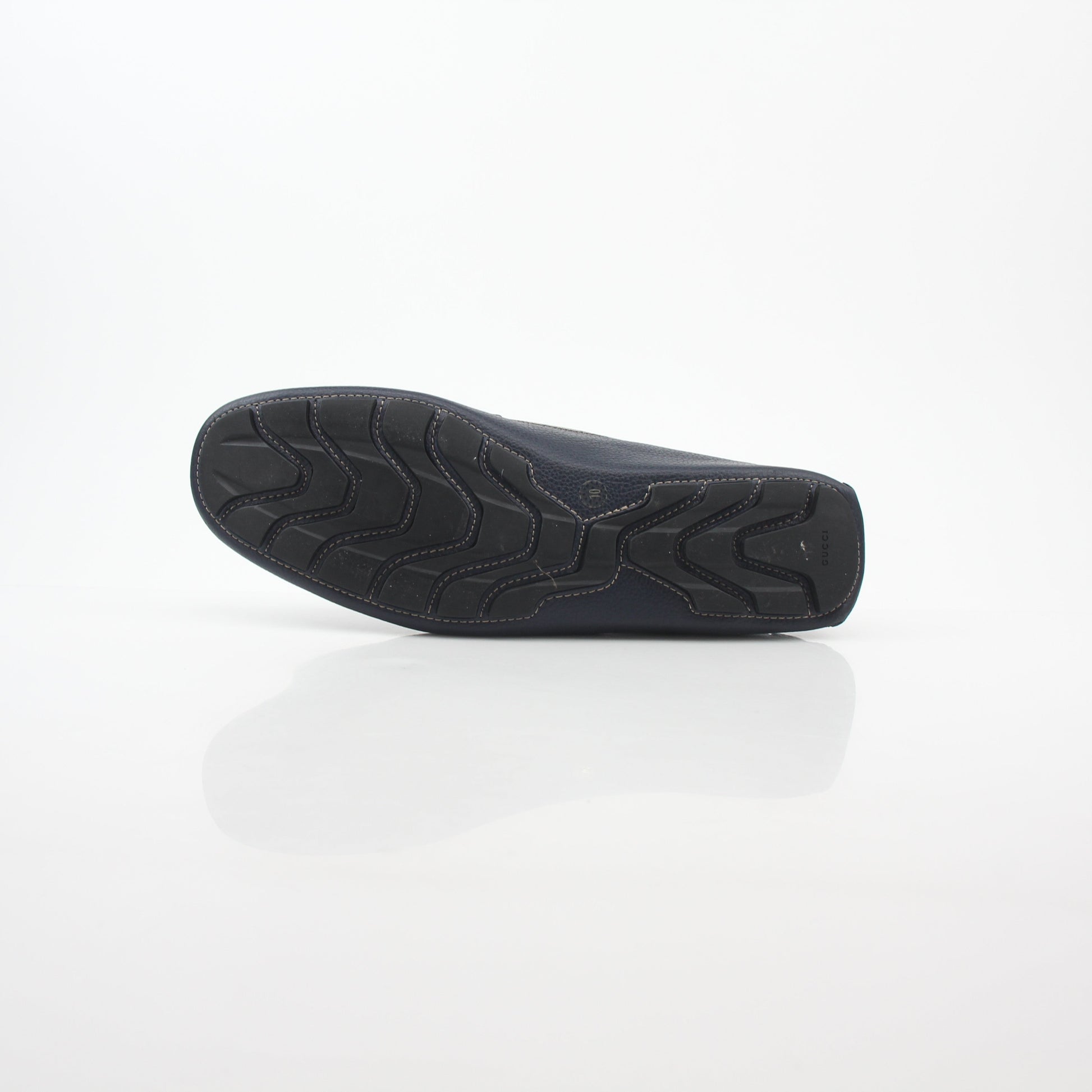 Gucci navy GG Supreme leather driver loafers with slip-on design and tan leather soles, stylish men's shoes from Gold & Beyond.