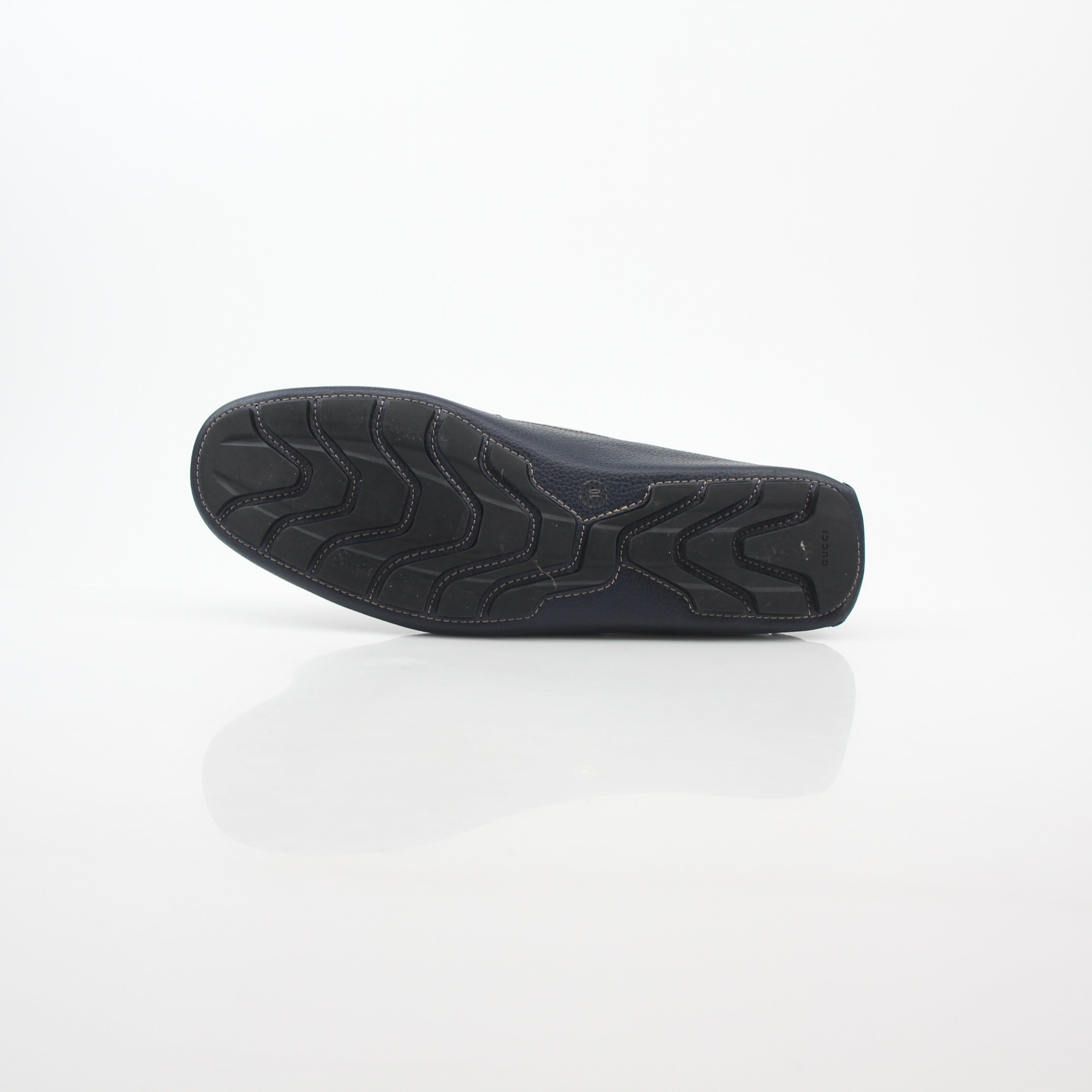 Gucci navy GG Supreme leather driver loafers with slip-on design and tan leather soles, stylish men's shoes from Gold & Beyond.