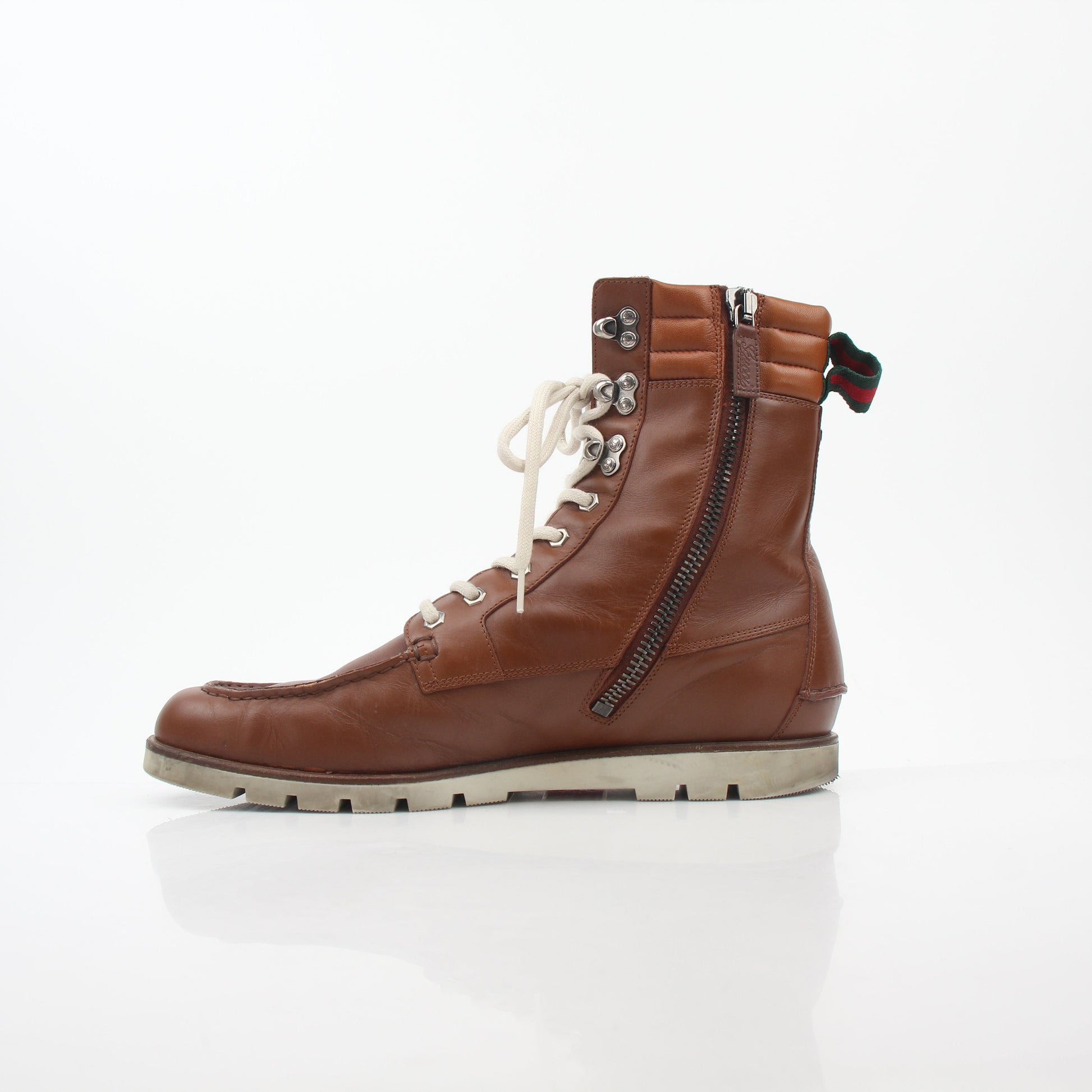 Gucci brown leather web accent hiking boots, shoes with rugged design and stylish detailing, shown on a plain background.