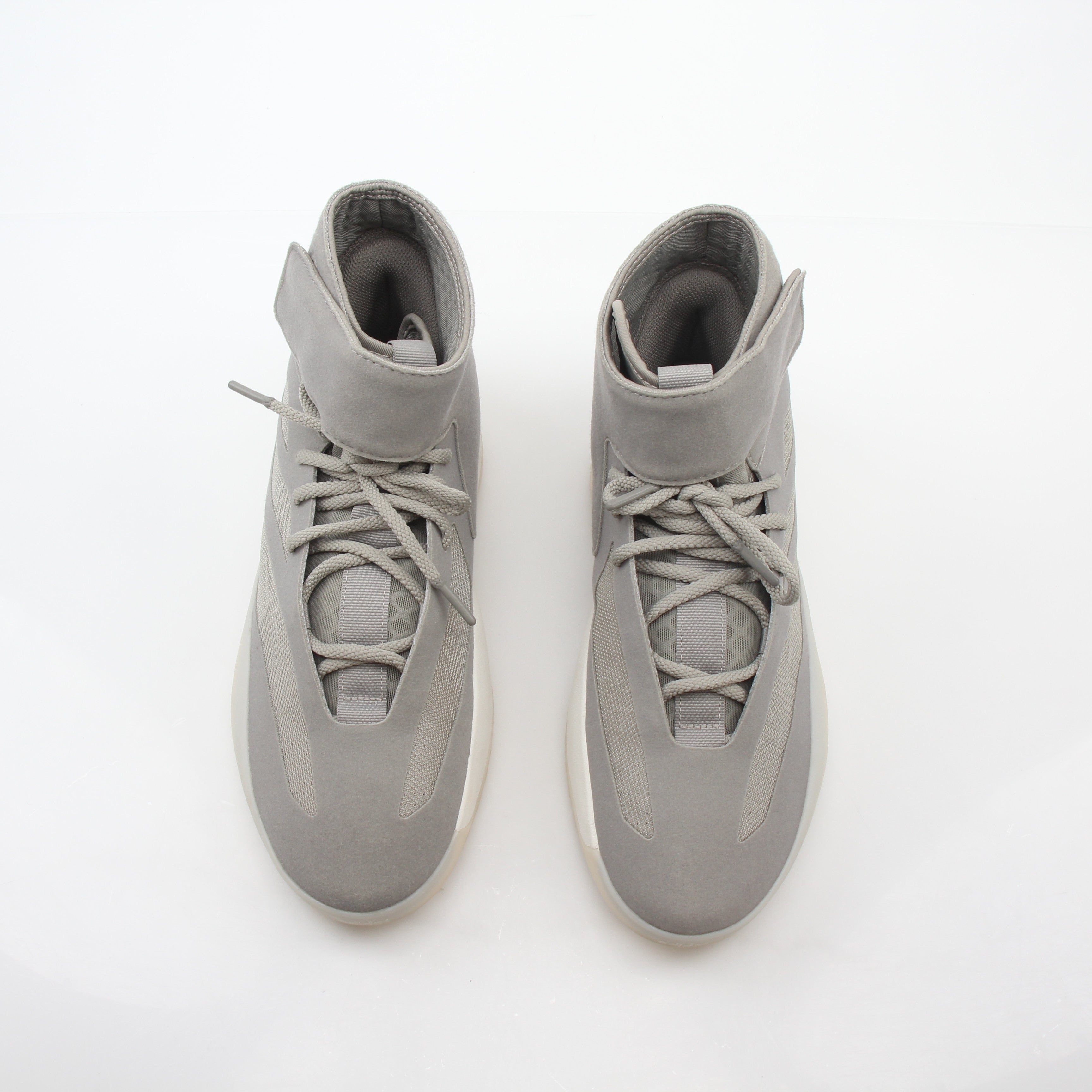 Beige Adidas x Fear of God Putty Athletics II basketball sneakers with high-top design and gold accents, displayed on a plain background.