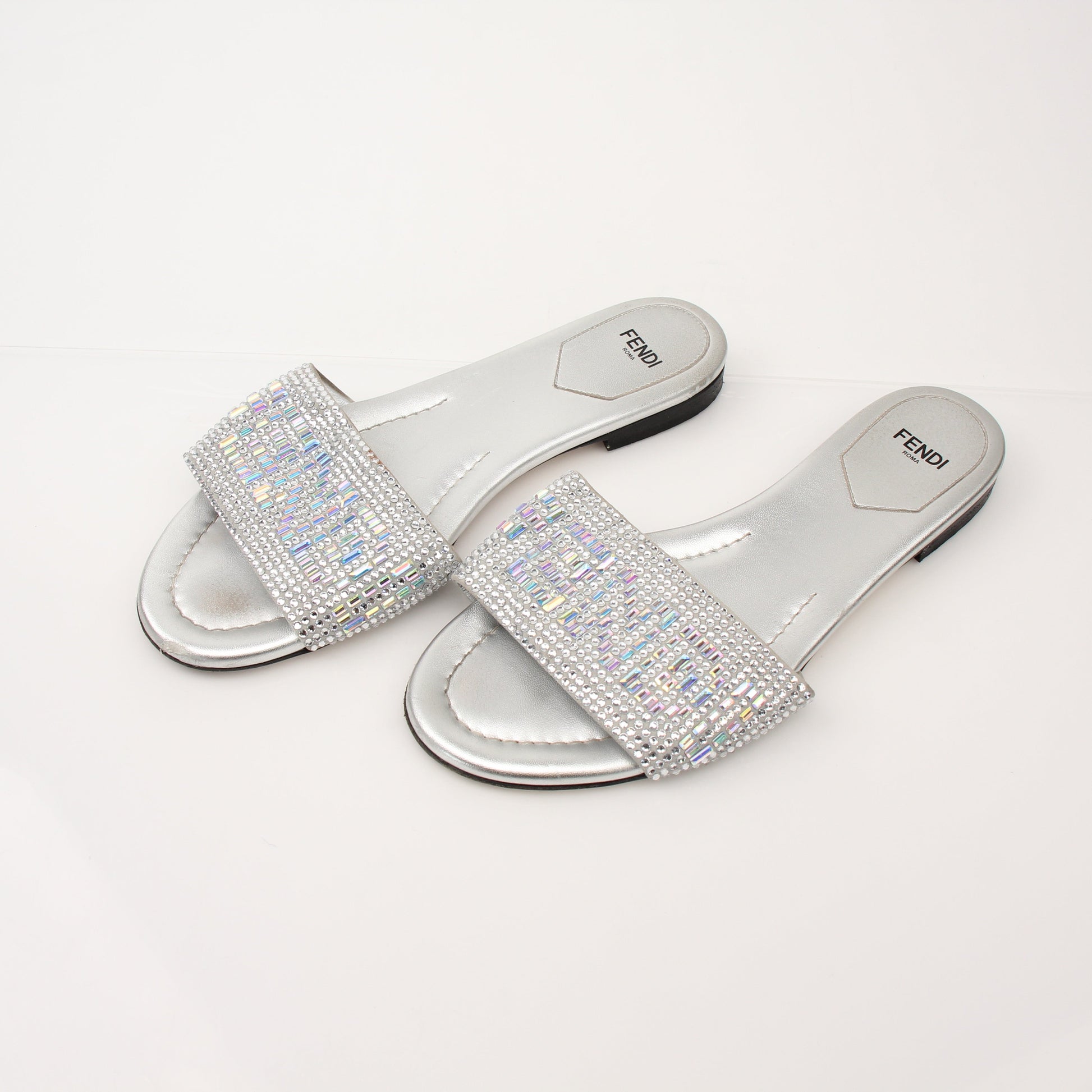 Fendi women's crystal-embellished signature slides with gold-tone details and open-toe design, displayed on a neutral background.