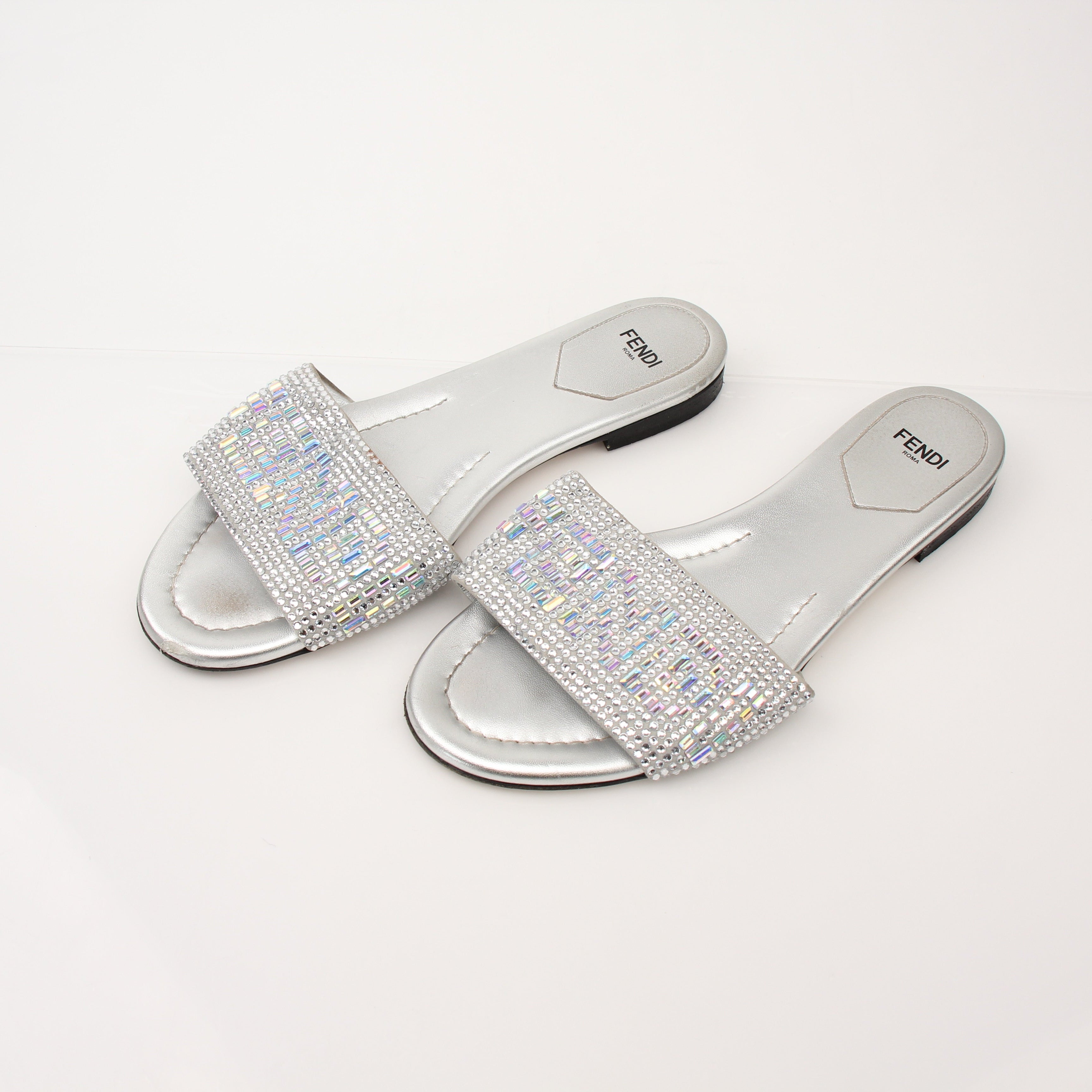 Fendi women's crystal-embellished signature slides with gold-tone details and open-toe design, displayed on a neutral background.